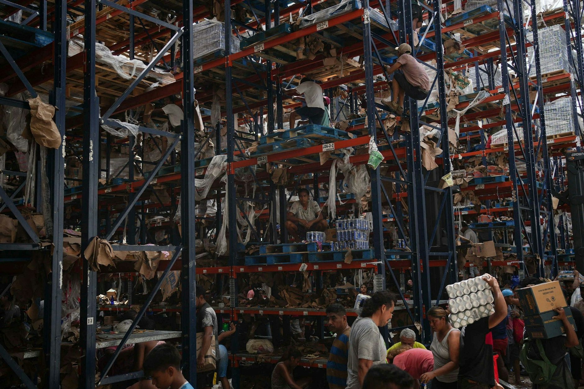 Menschen nehmen nach Hurrikan «Otis» Gegenstände aus einem Geschäft mit.  