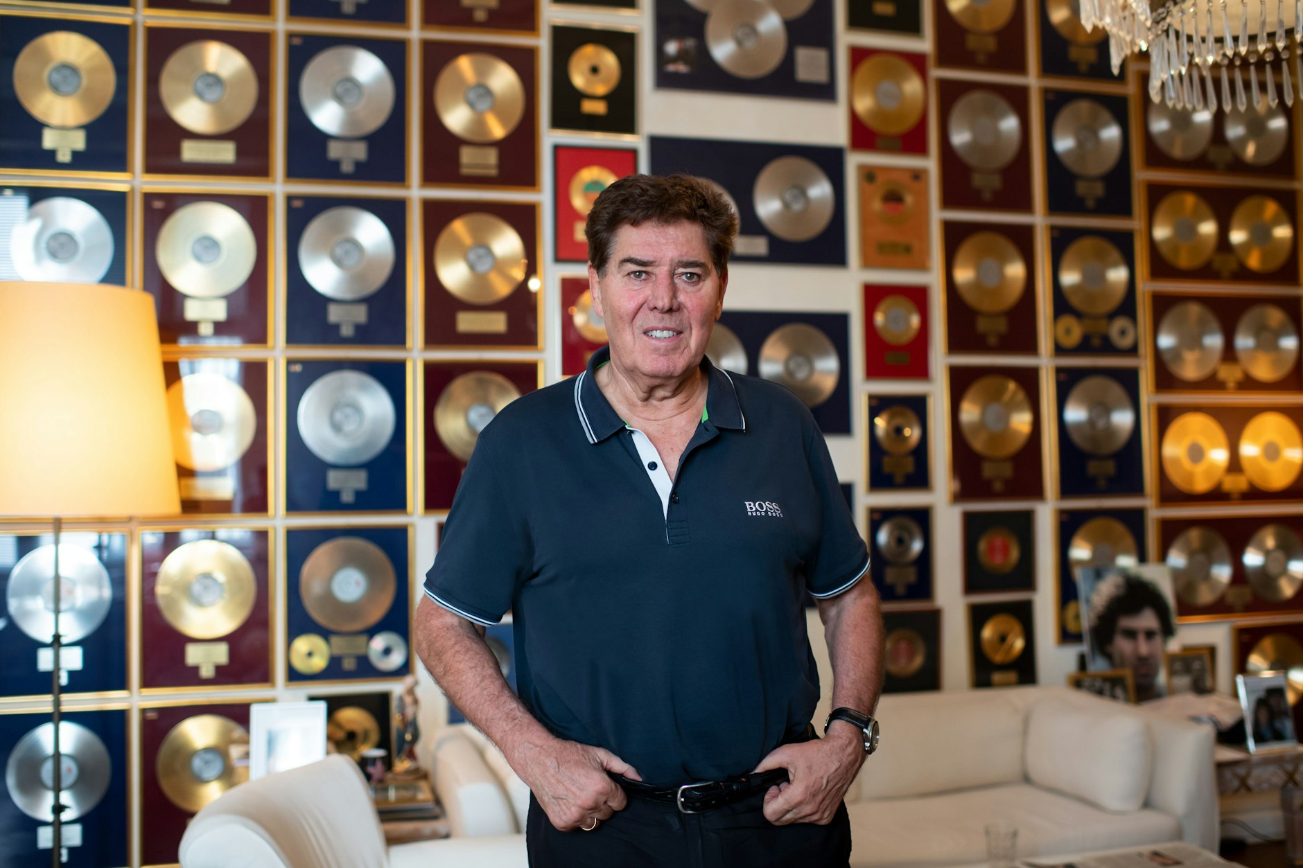 Musikproduzent Jack White steht in seiner Wohnung in Berlin-Charlottenburg, an der Wand hängen zahlreiche Goldene und Platin-Schallplatten.