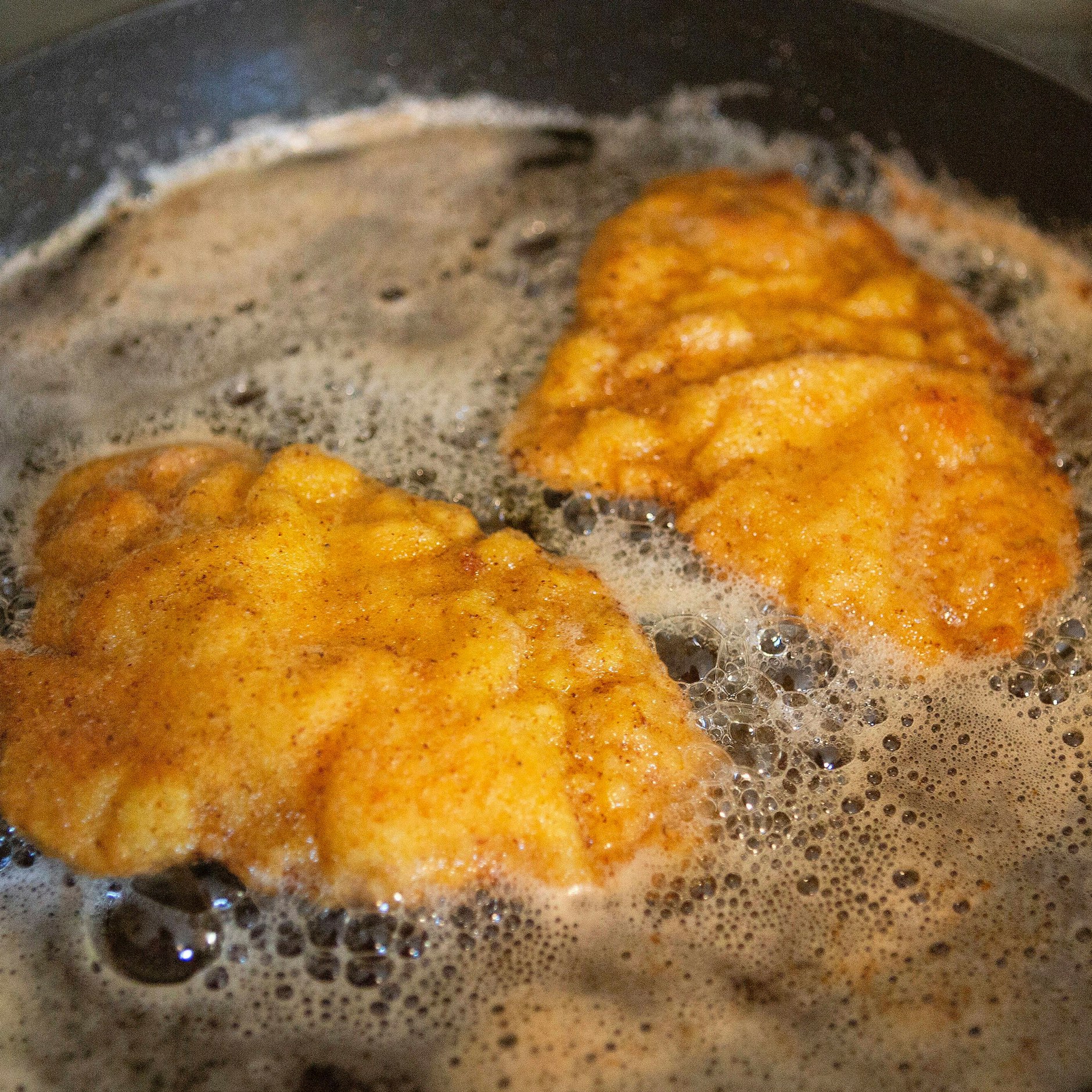 Die Parmesan-Schnitzel werden in reichlich Fett in der Pfanne goldgelb gebacken.