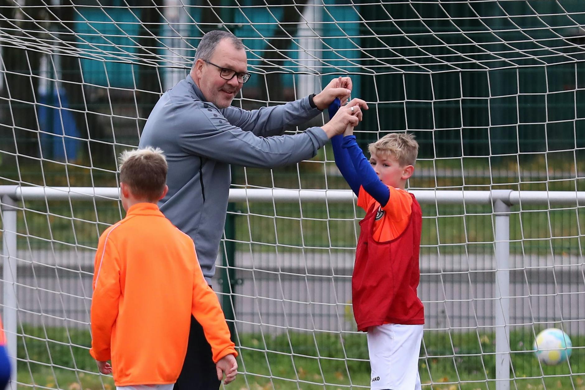Dynamos Mannschaftsleiter Jörn Lenz ist derzeit auch Kinderbeauftragter der Dynamos, klatscht im Feriencamp mit einem Knirps ab. 