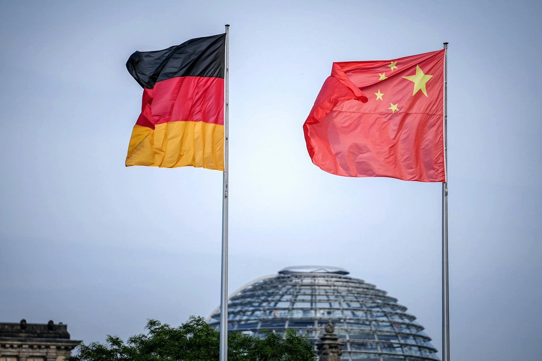 ARCHIV - Die Flaggen von Deutschland und China wehen zum Auftakt des Deutschland-Besuchs der chinesischen Regierung vor dem Bundeskanzleramt, im Hintergrund die Kuppel des Reichstagsgebäudes.