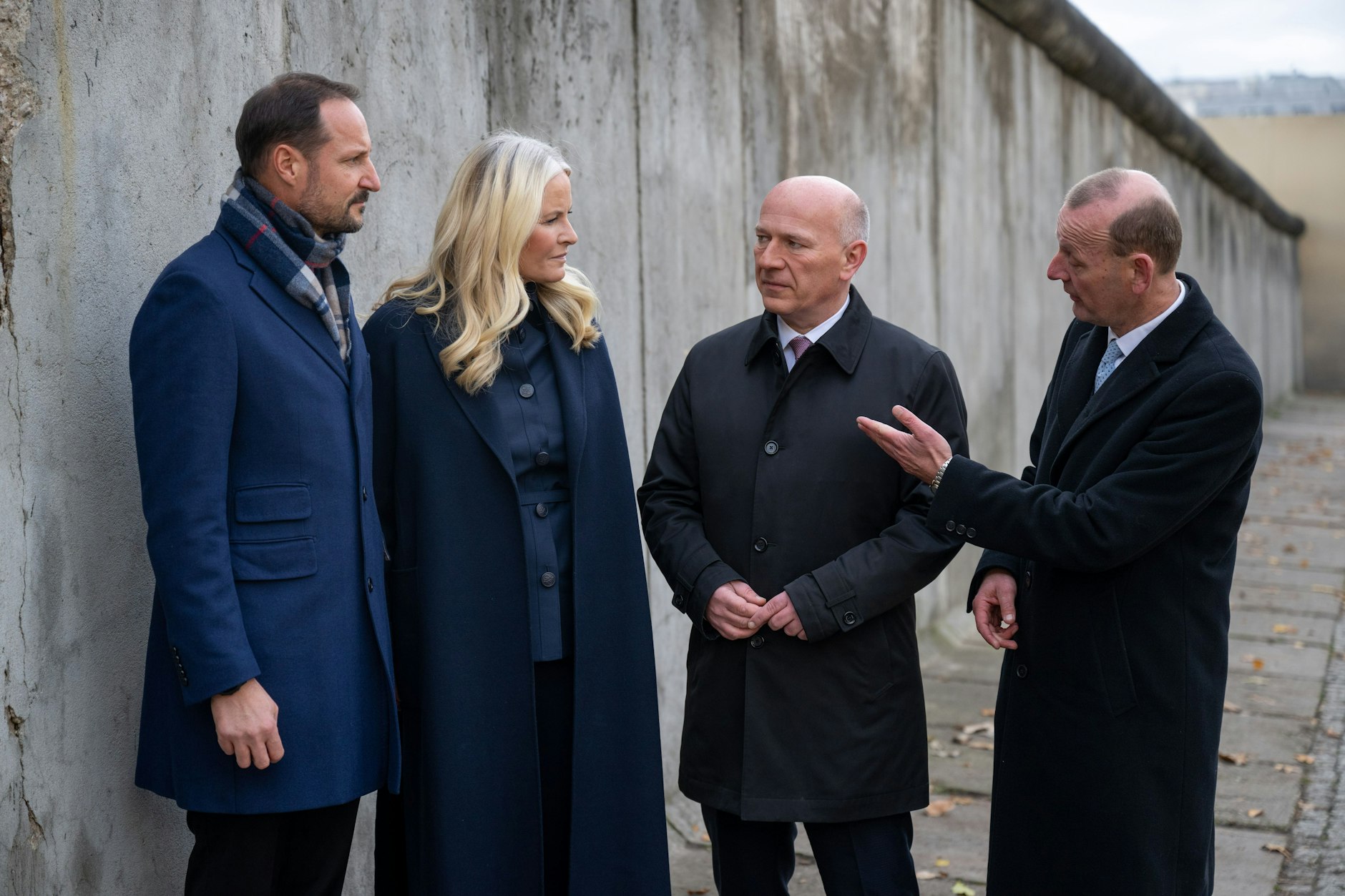 Der Regierende Bürgermeister Kai Wegner (2.v.r.) und Axel Klausmeier, Direktor der Stiftung Berliner Mauer (r.), treffen Norwegens Kronprinz Haakon (l.) und seine Frau Mette-Marit an der Mauergedenkstätte Bernauer Straße.