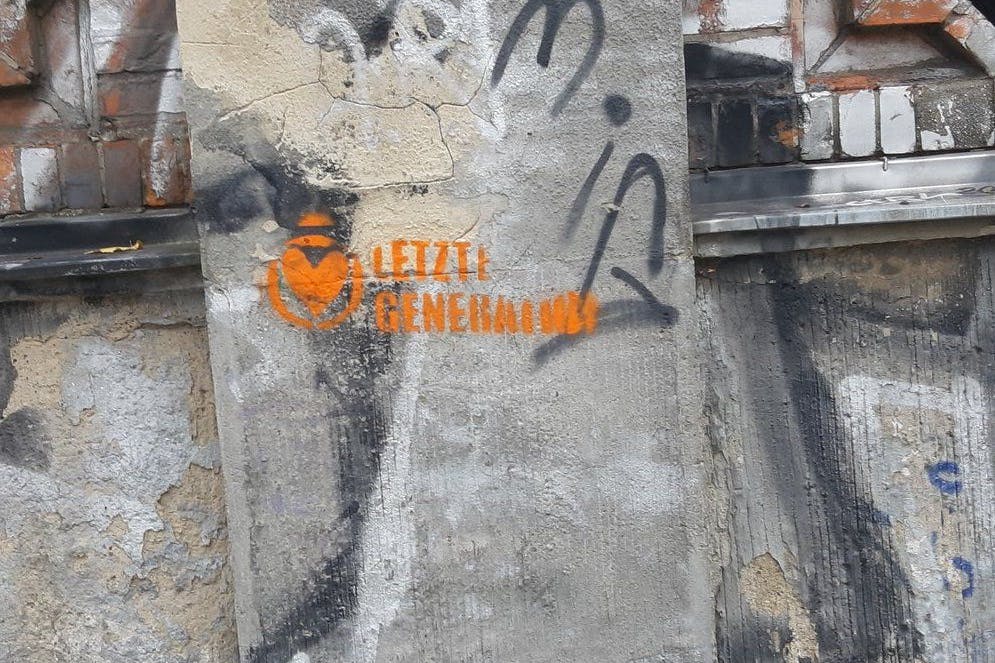 Das Logo der Letzten Generation prangt an der Außenmauer eines jüdischen Friedhofs in Prenzlauer Berg.