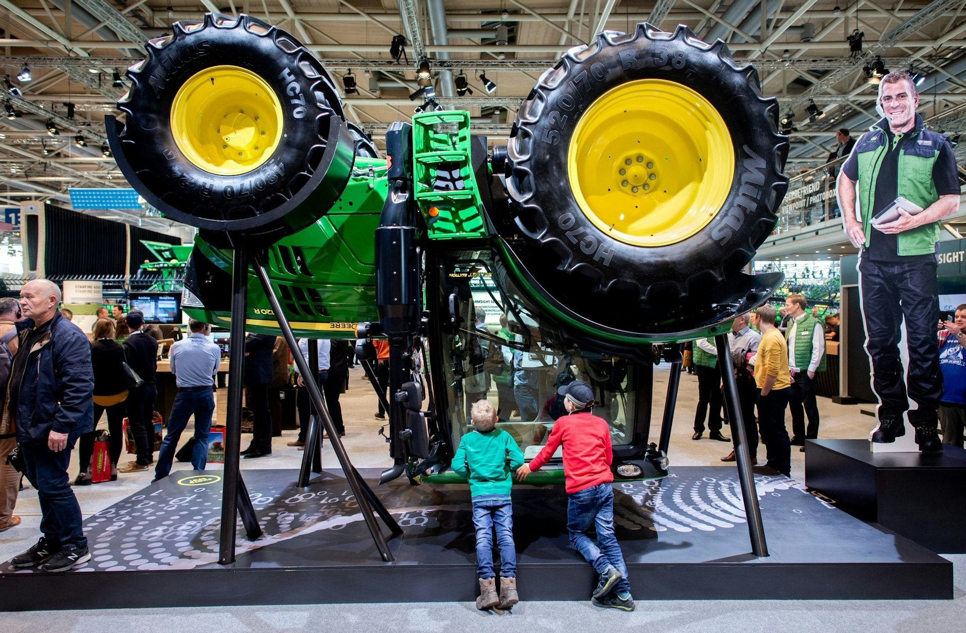 ARCHIV - Zwei Jungen betrachten am Stand von John Deere auf der Landtechnik-Messe Agritechnica in der Messe Hannover einen Traktor, der für die Präsentation umgedreht wurde.  