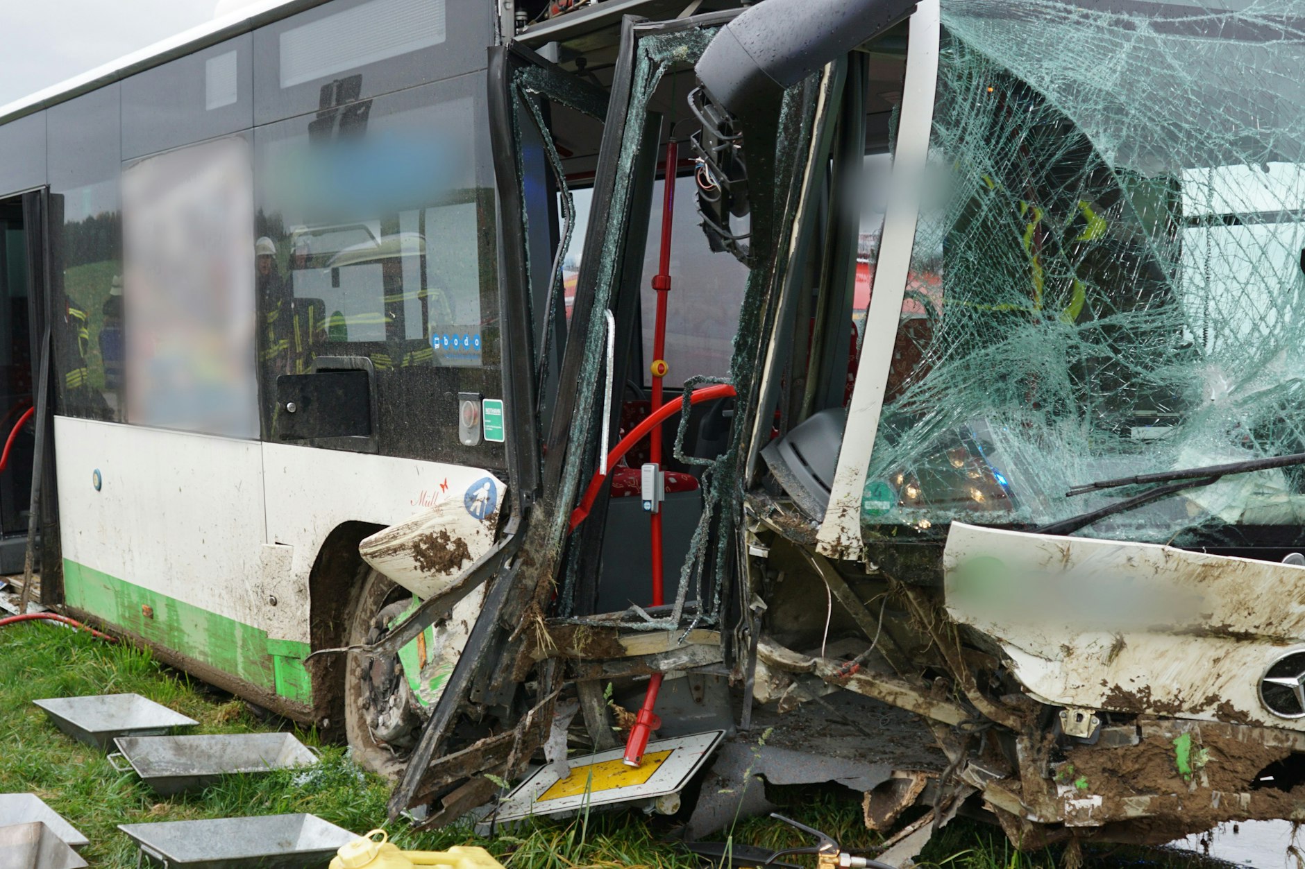 Der schwer beschädigter Schulbus steht nach einem Unfall mit mehreren Verletzten an einer Straße.