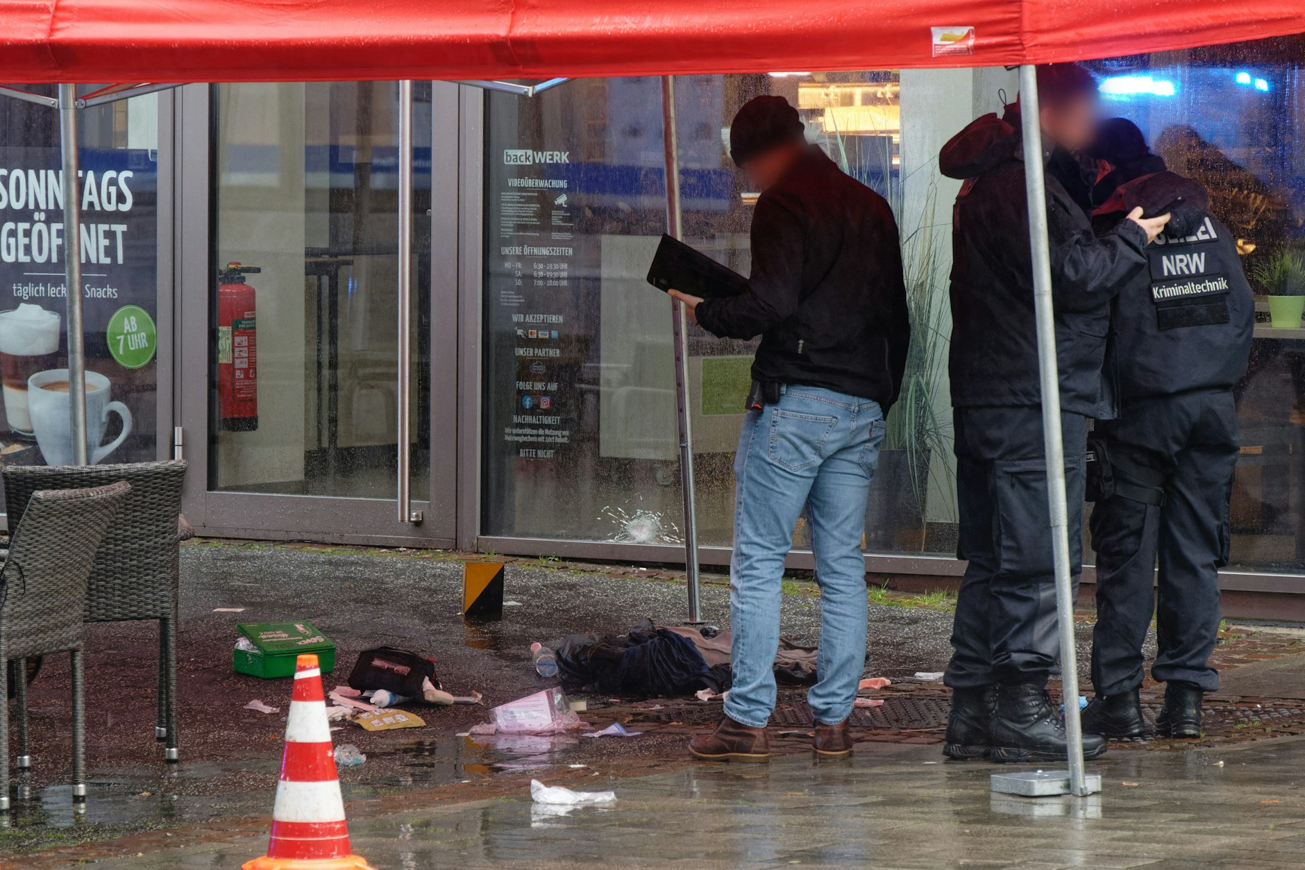 Polizeibeamte untersuchen unter einem Zeltdach den Tatort in der Innenstadt. Nach Schüssen mit mehreren Verletzten hat die Polizei den Tatort weiträumig abgesperrt.
