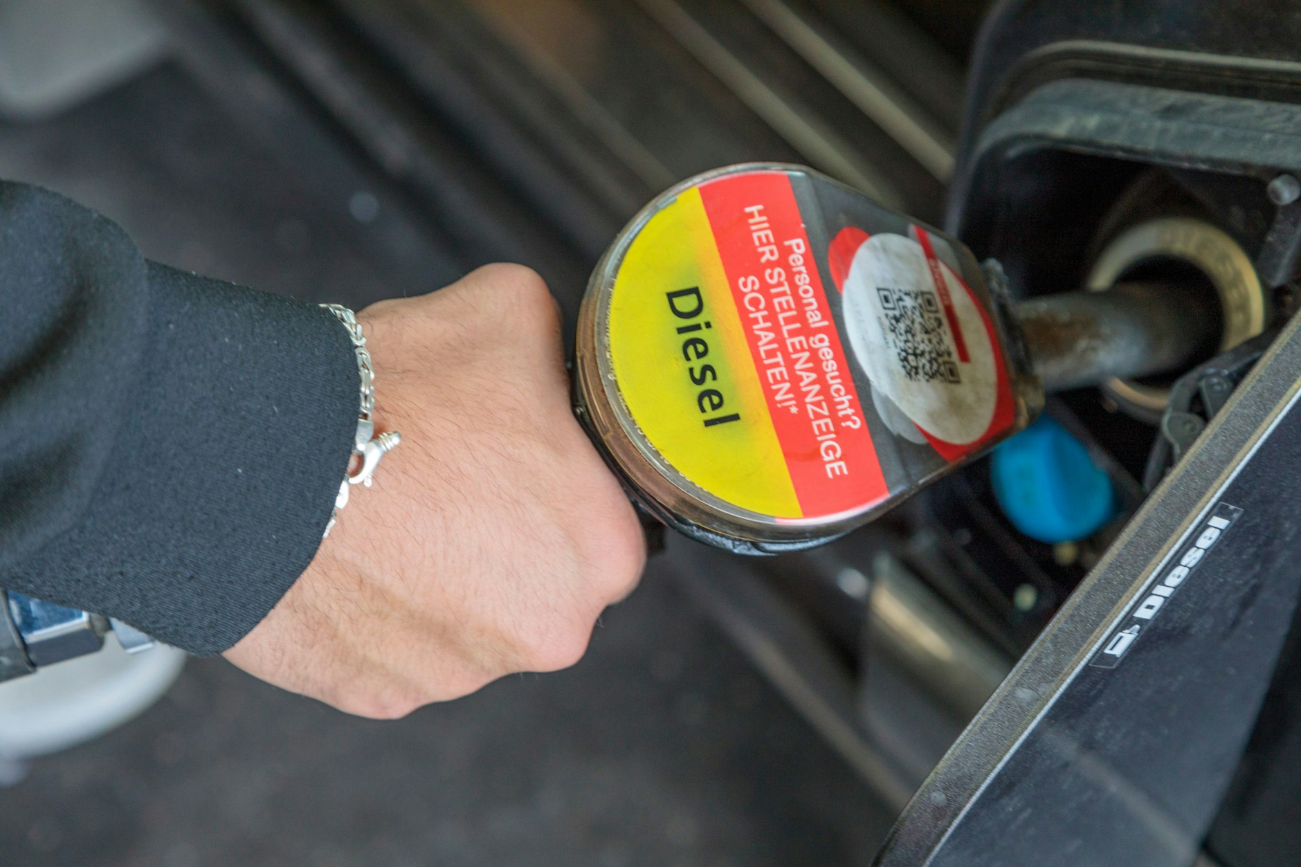 Ein Mann tankt an einer Tankstelle Diesel. 