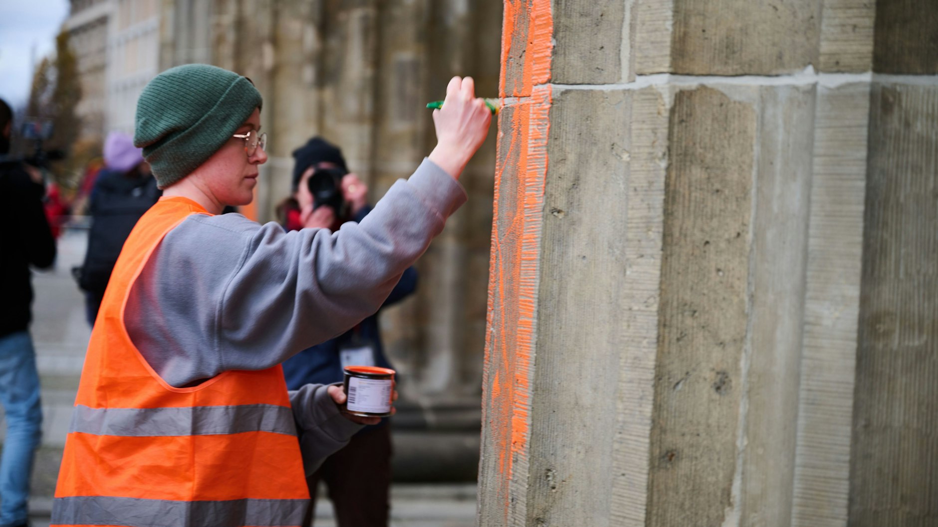 Eine Klimaaktivistin bemalt das Brandenburger Tor mit oranger Farbe. Hierbei handelt es sich KURIER-Informationen nach um Regina Stephan, die bereits bei der ersten Farb-Attacke auf das Berliner Wahrzeichen zu den Tätern gehörte.