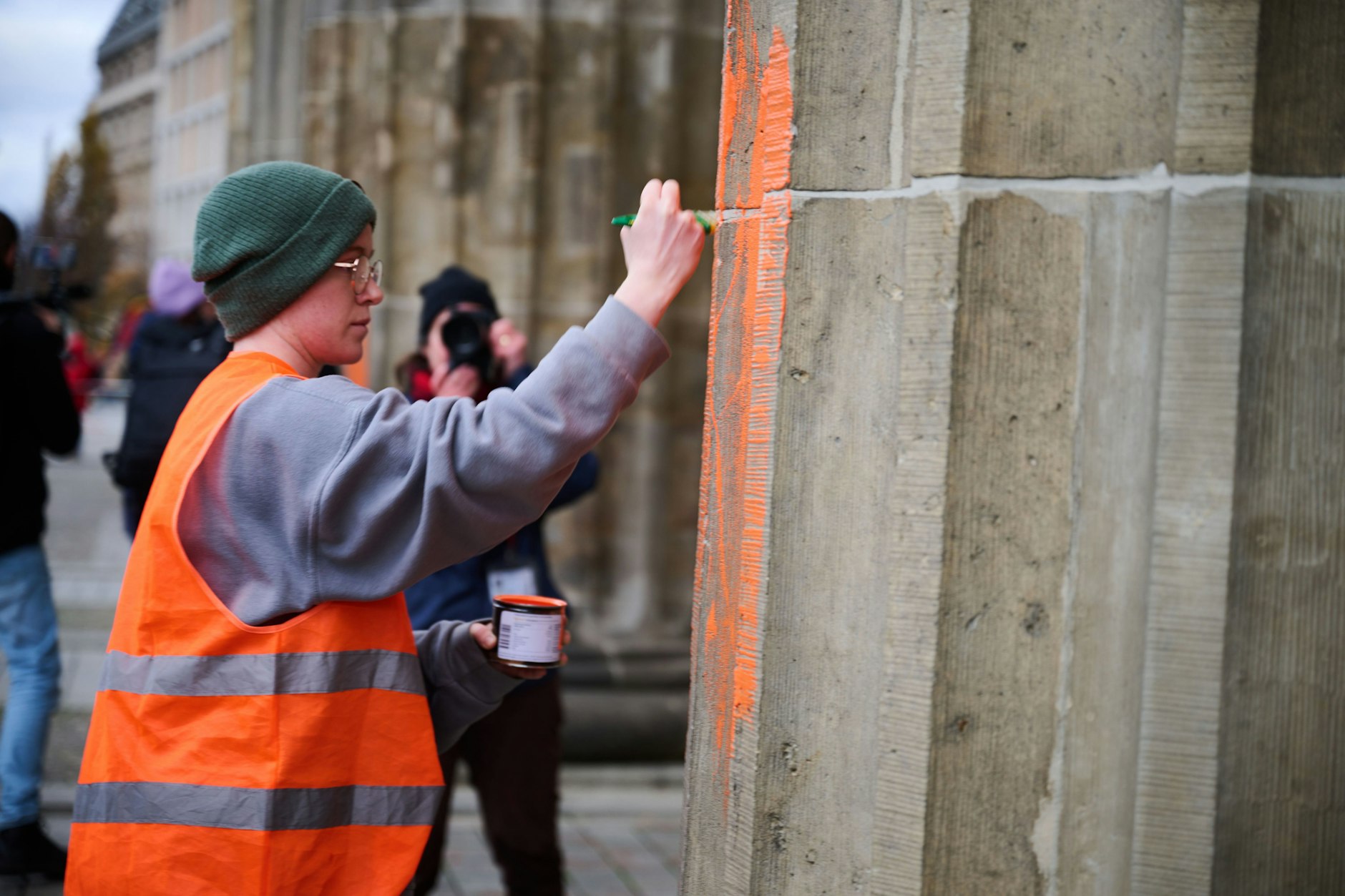 Eine Klimaaktivistin bemalt das Brandenburger Tor mit oranger Farbe. Hierbei handelt es sich KURIER-Informationen nach um Regina Stephan, die bereits bei der ersten Farb-Attacke auf das Berliner Wahrzeichen zu den Tätern gehörte.
