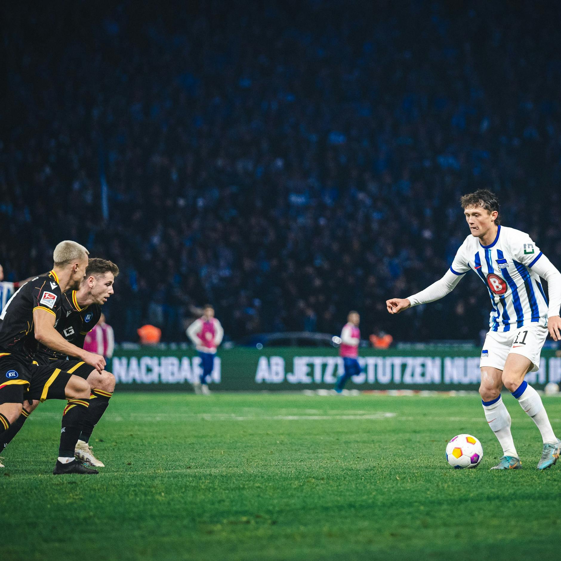 Herthas Fabian Reese setzt gegen zwei Karlsruher zum Dribbling an.