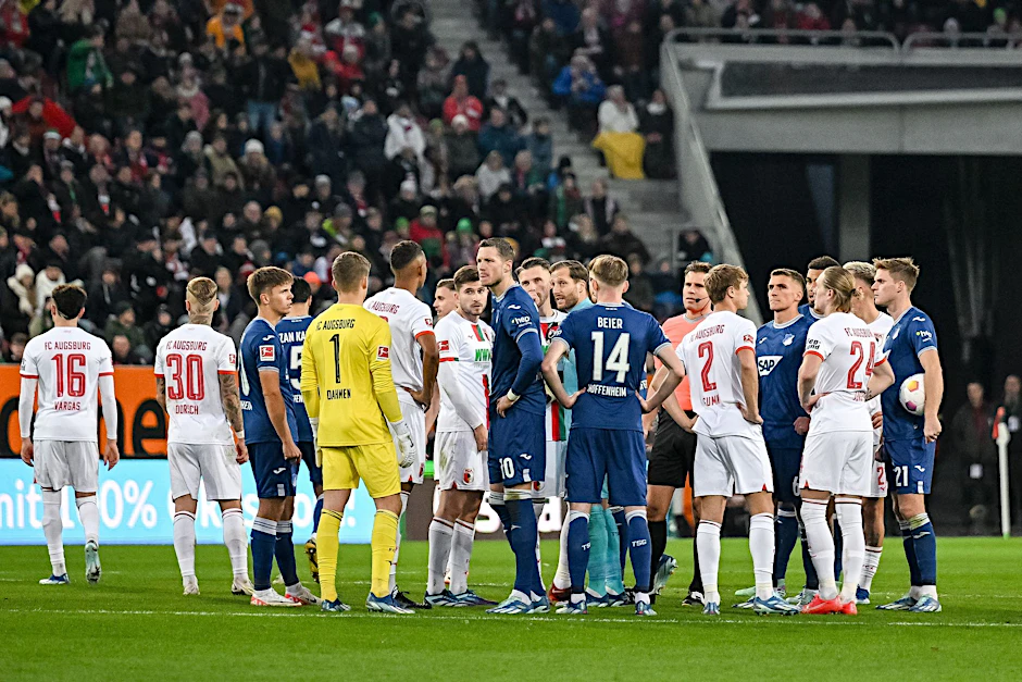 Schiedsrichter Felix Brych bespricht sich mit den Spielern am Mittelkreis.  
