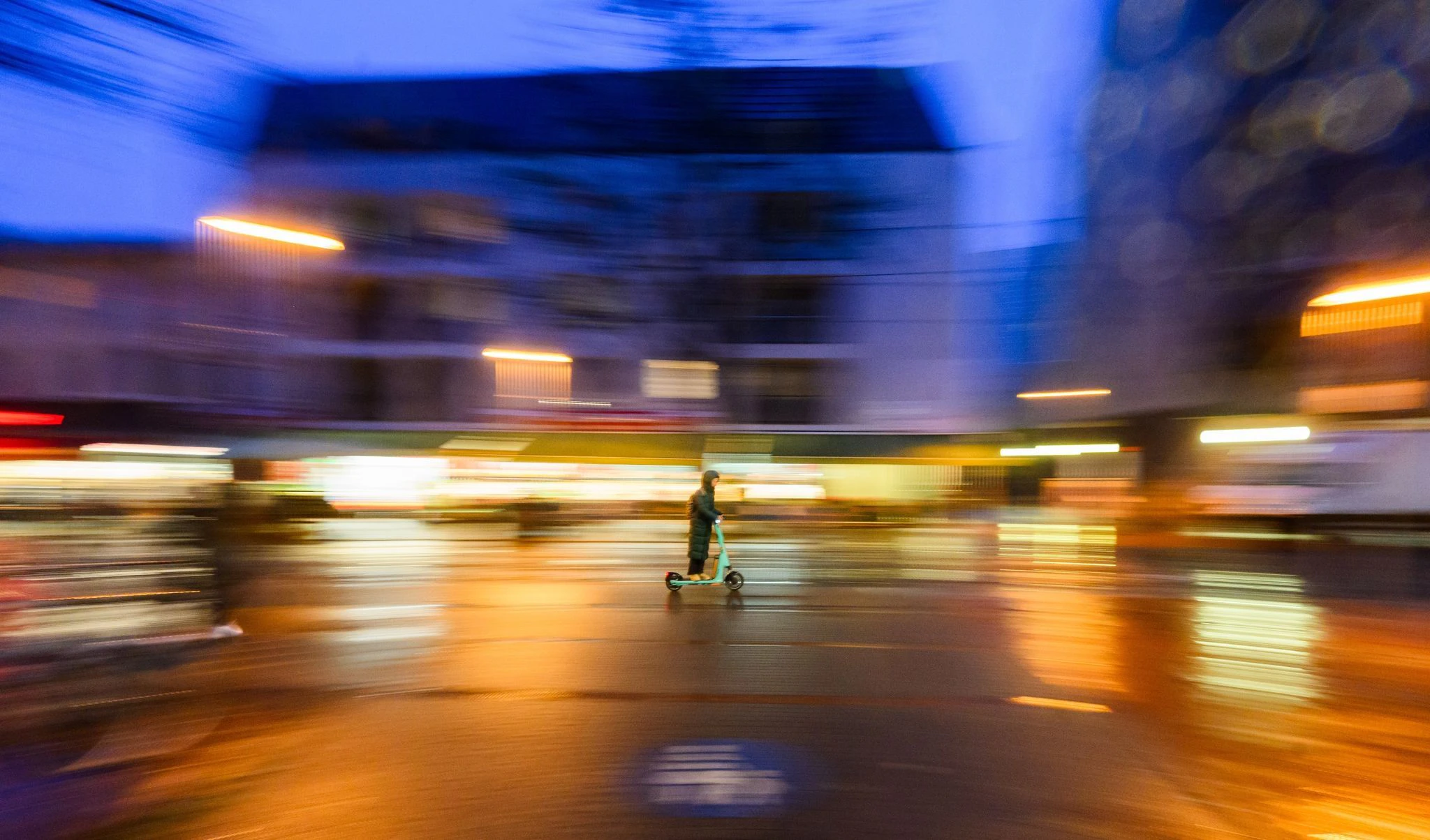 dpatopbilder - Eine Frau fährt in der Dämmerung mit einem Elektroroller durch Hannover.  