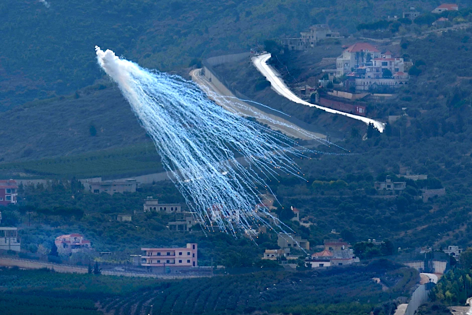 22.11.2023, Libanon: Brennende Teile eines Geschosses fallen nach einem israelischen Angriff über Kfar Kila, einem libanesischen Grenzdorf zu Israel. 
