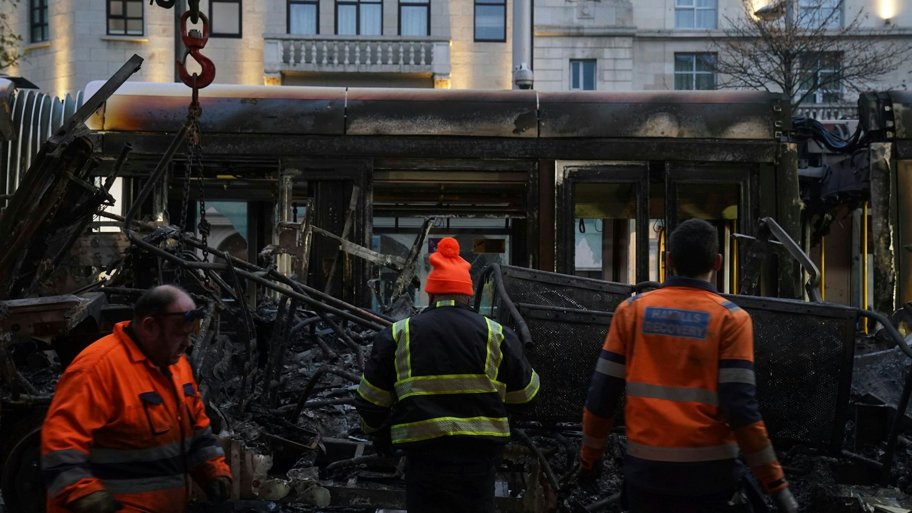 Ein ausgebrannter Bus wird am Tag nach den gewalttätigen Szenen im Stadtzentrum in Dublin von der O'Connell Street entfernt.