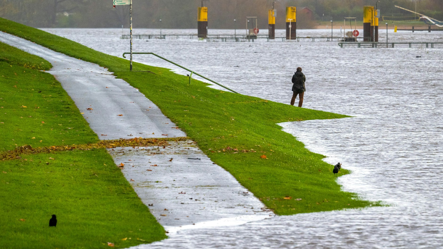 Eine Spaziergängerin steht bei Hochwasser am Osterdeich in Bremen. An der Nordsee hat die Sturmflut viel Wasser an Land und Küsten gedrückt.