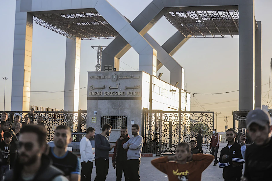 Palästinenser versammeln sich vor dem Tor des Grenzübergangs Rafah.  