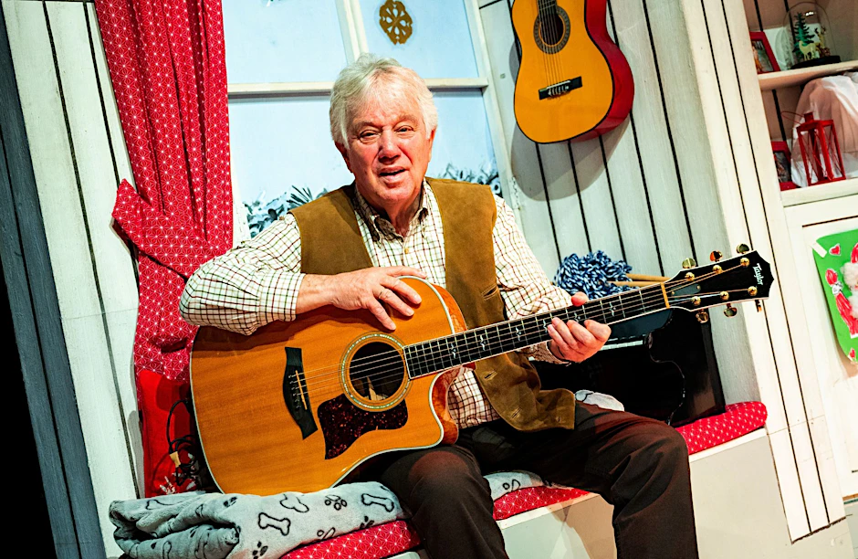 ARCHIV - Liedermacher Rolf Zuckowski sitzt bei einem Fototermin mit seiner Gitarre im Schmidts Tivoli.  