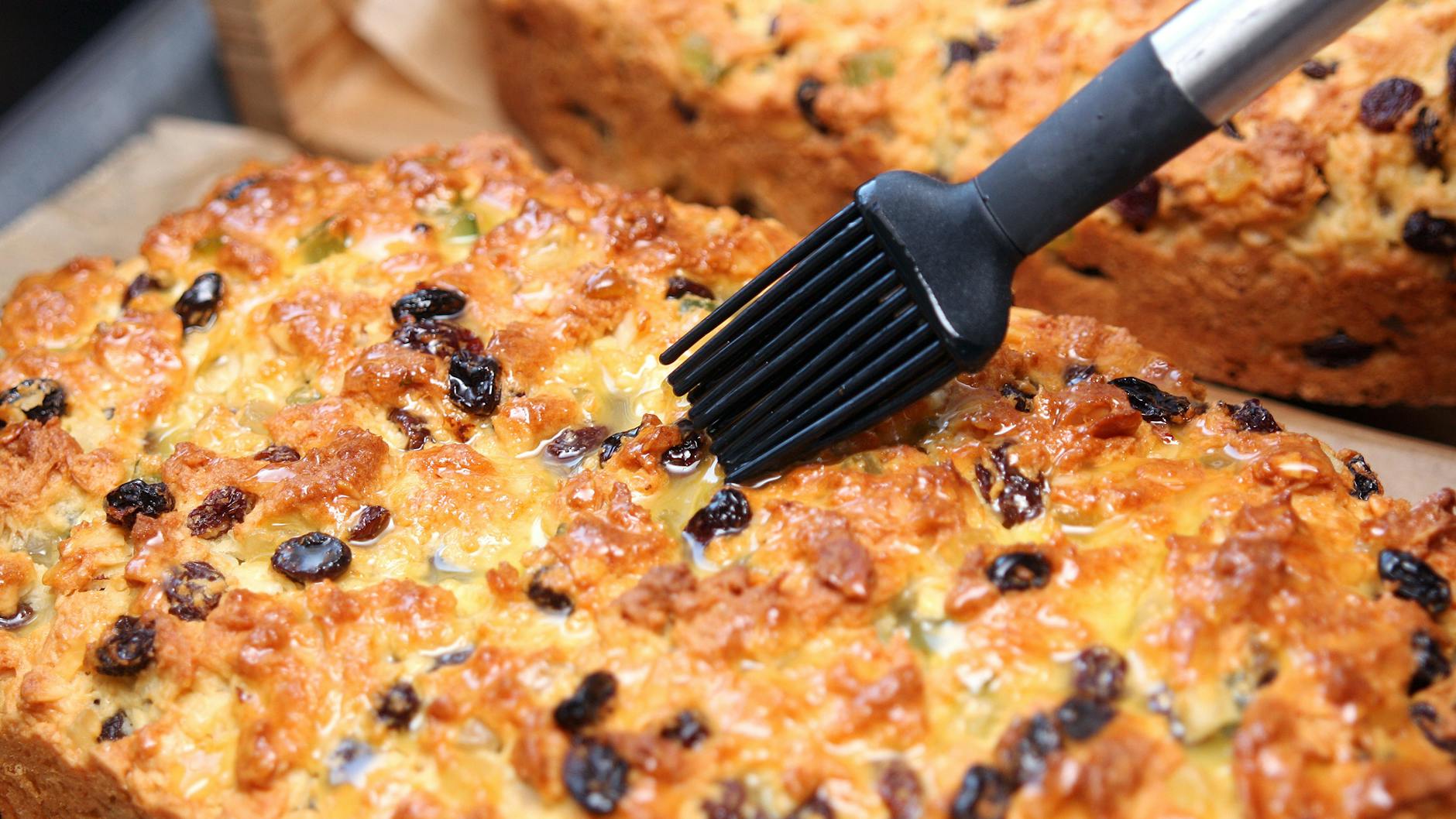 Wichtig beim Rezept für Dresdner Christstollen: Den Stollen großzügig mit Butter bestreichen und dann mit Puderzucker bestäuben.