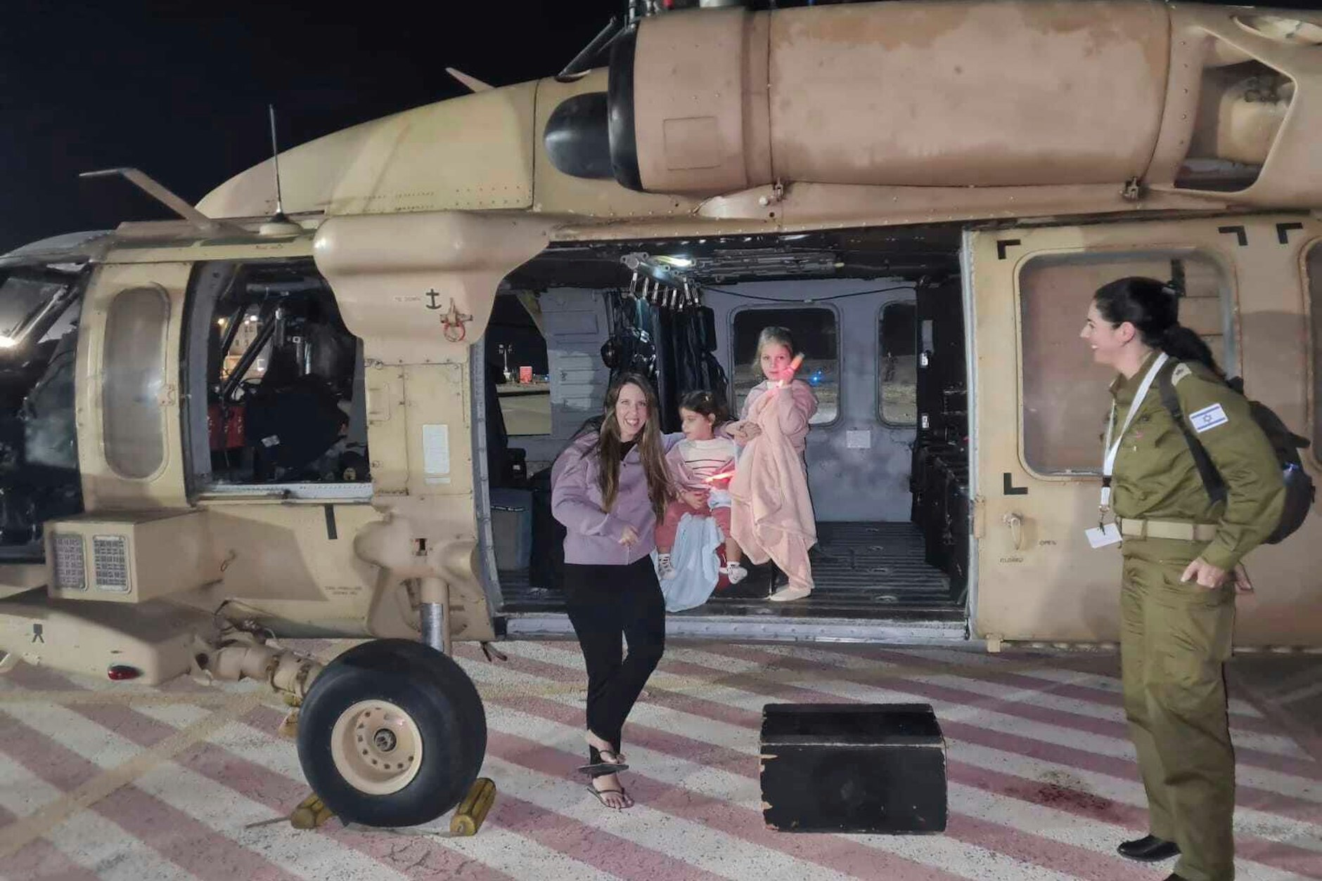 Aviv (2 ), ihre Schwester Raz&nbsp; (4) und die Mutter Doron Asher am Freitag vor einem Armee-Hubschrauber in Israel.