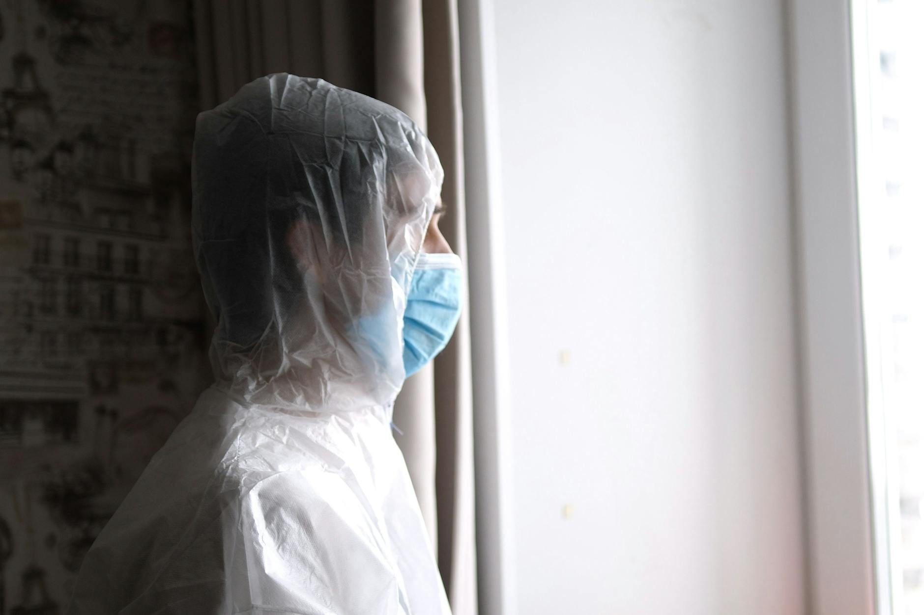 Ein medizinischer Mitarbeiter mit Maske und Overall 