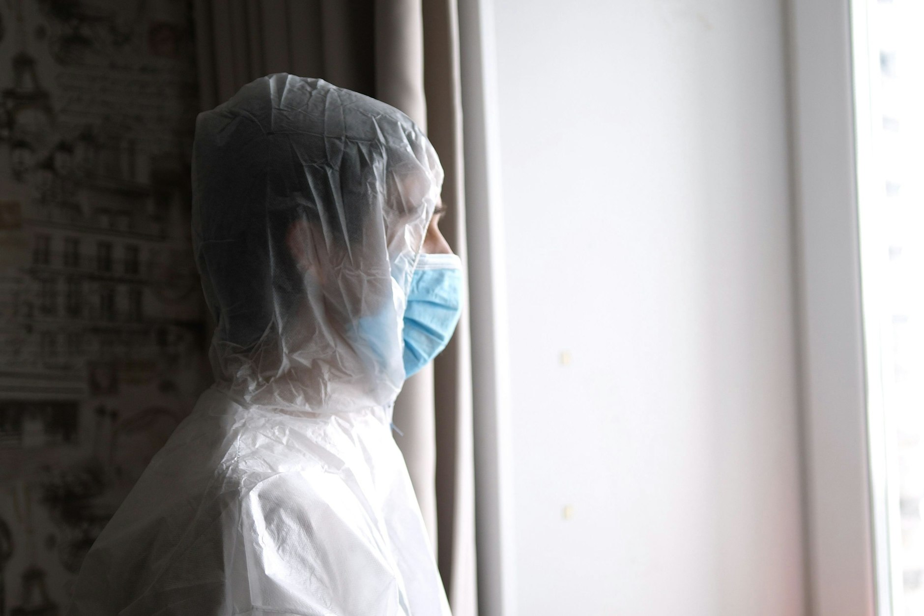 Ein medizinischer Mitarbeiter mit Maske und Overall&nbsp;