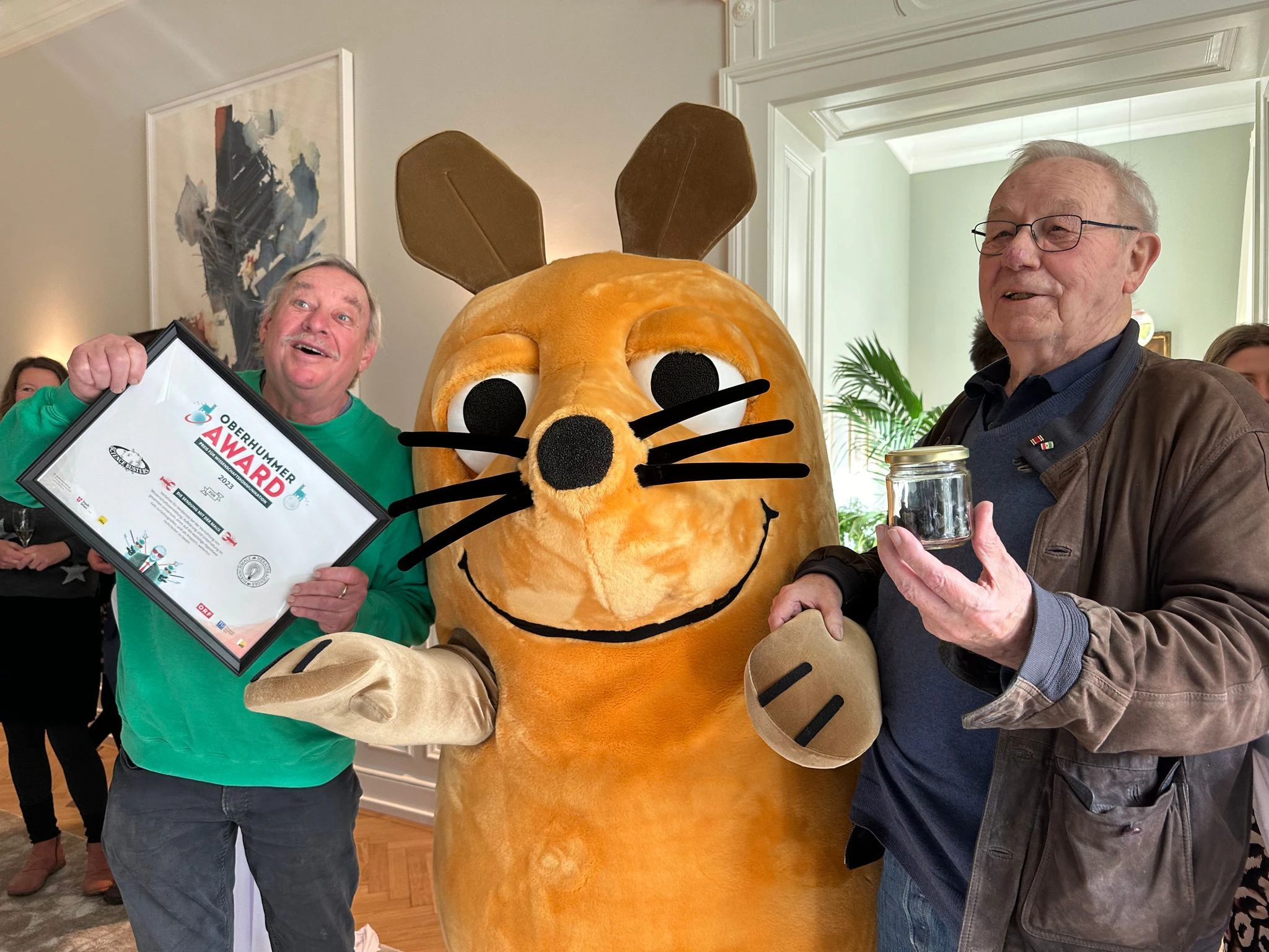 Ungewöhnlicher Pokal: Das «Sendung mit der Maus»-Team erhält in Wien den «Heinz Oberhummer Award für Wissenschaftskommunikation» in Form eines Glases voller Alpakakot.  
