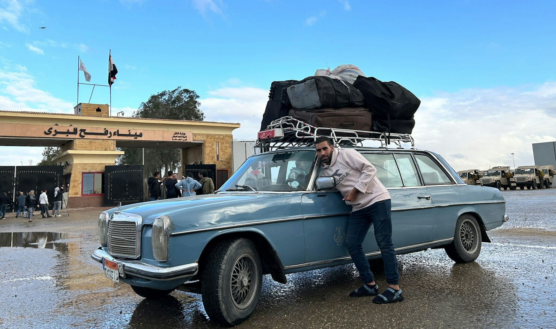 PRODUKTION - Ein Fahrer, der Palästinenser zur Rückkehr in den Gazastreifen zur Grenze bringt, steht auf der ägyptischen Seite am Grenzübergang Rafah.  