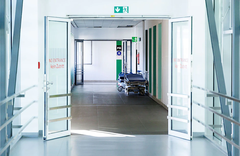 ARCHIV - Krankenbetten stehen in einem Gang in einem Krankenhaus.  