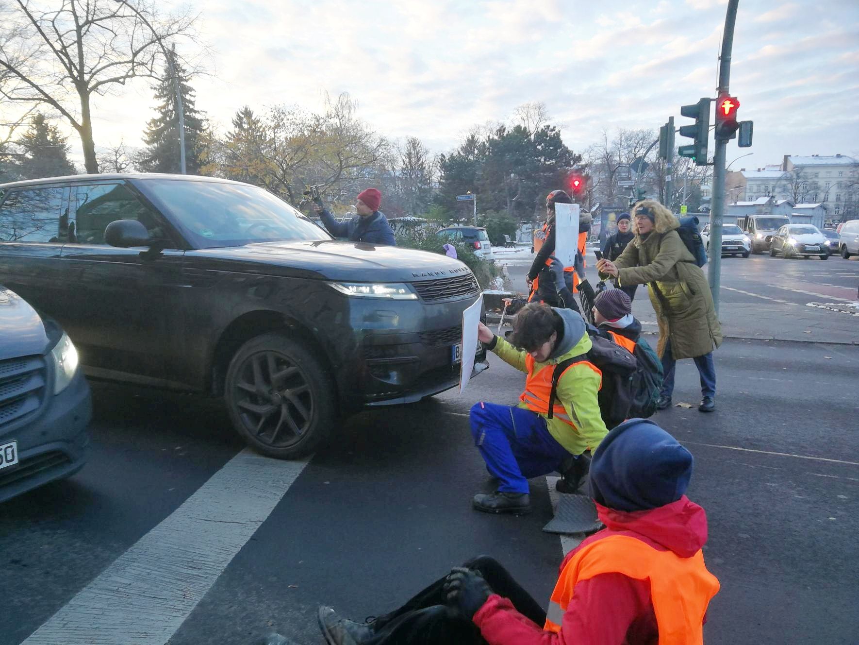 Handwerker der Letzten Generation kleben bei Minusgraden in Berlin am Asphalt