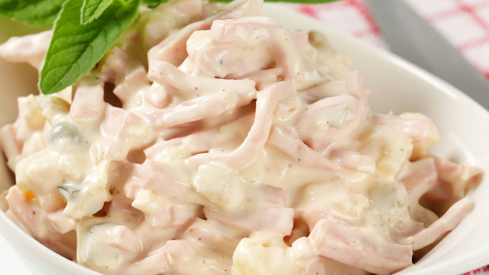 Bei diesem Kartoffelsalat-Rezept wird aus dem fertigen Fleischsalat ein leckeres Dressing.