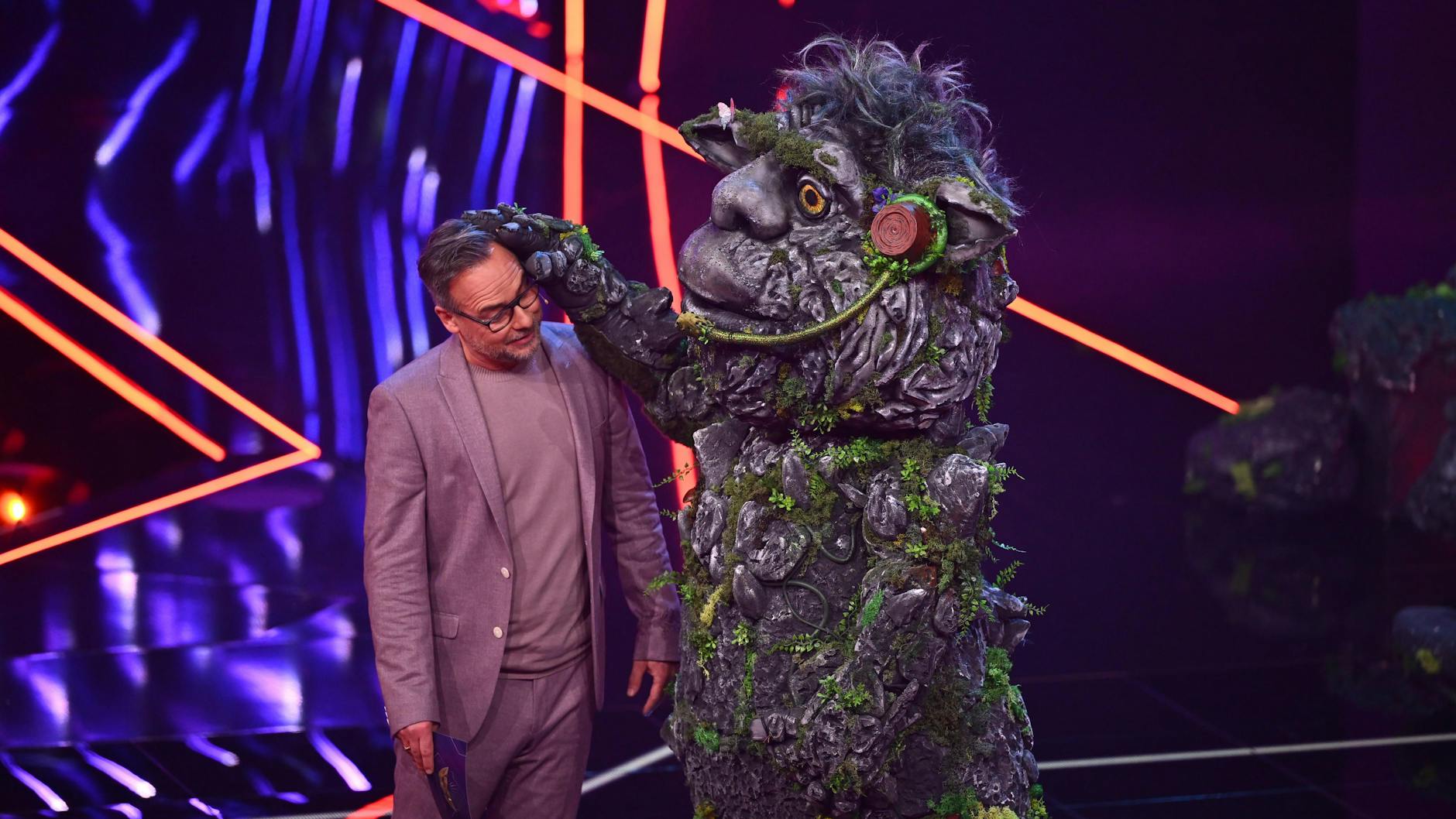 „Masked Singer“-Moderator Matthias Opdenhövel mit dem Troll im TV-Studio. Fans glauben, dass unter dem mystischen Kostüm ein Star mit Opern-Ausbildung steckt.