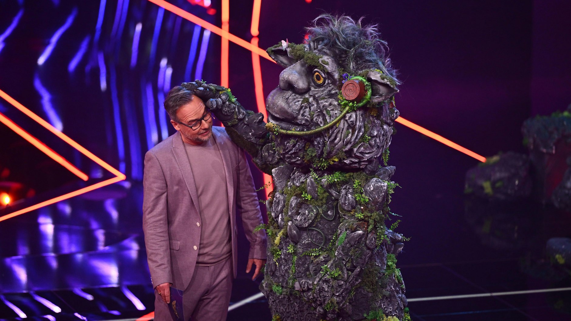 „Masked Singer“-Moderator Matthias Opdenhövel mit dem Troll im TV-Studio. Fans glauben, dass unter dem mystischen Kostüm ein Star mit Opern-Ausbildung steckt.