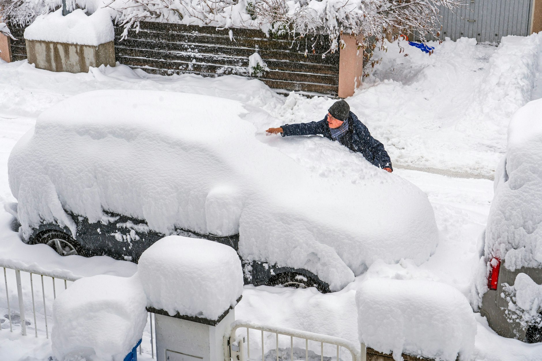 Ein Münchner versucht, sein Auto von einem halben Meter Schnee zu befreien. 