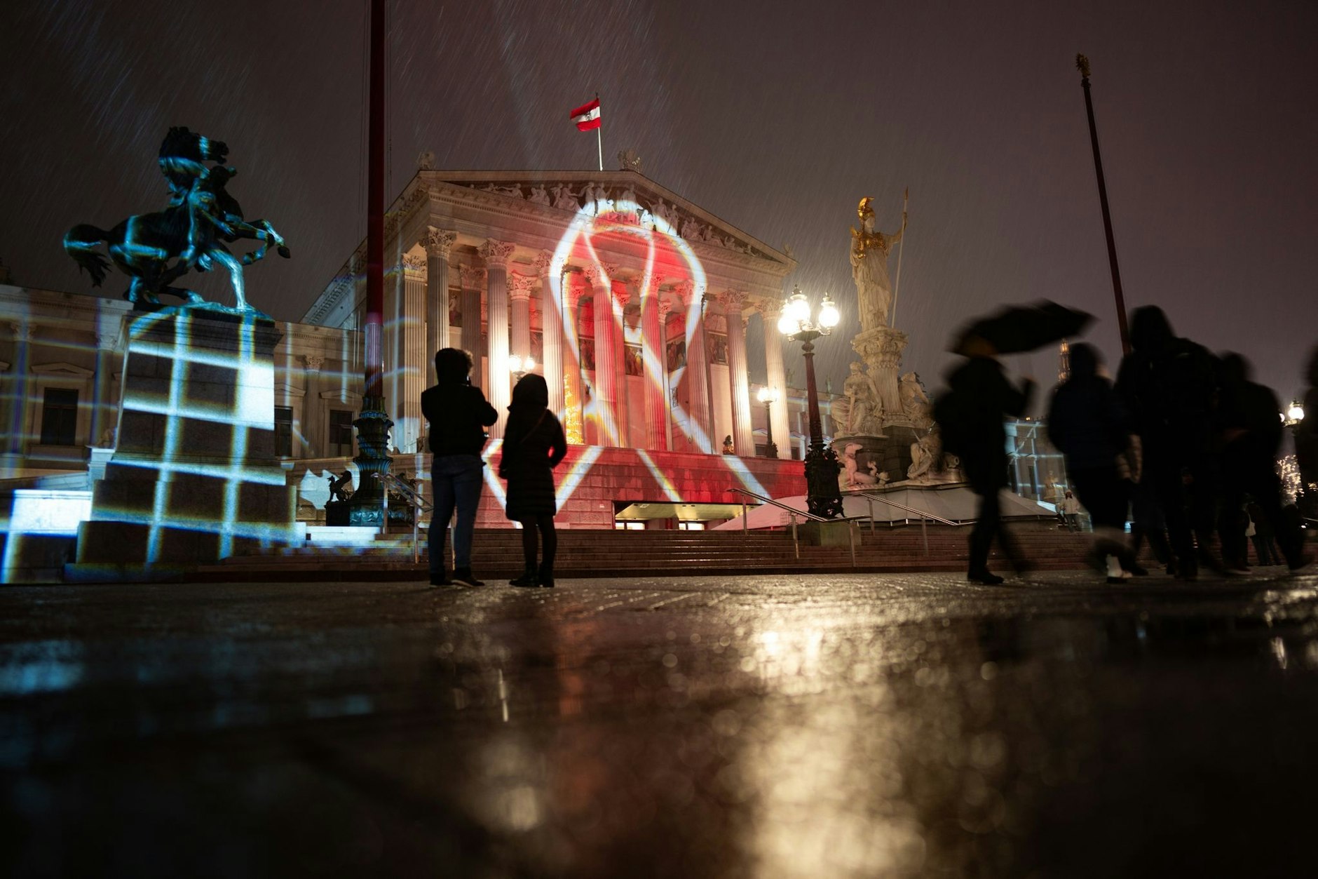 dpatopbilder - Die Fassade des Parlamentsgebäudes in Wien wird anlässlich des Welt-Aids-Tages mit dem Red Ribbon angestrahlt.  