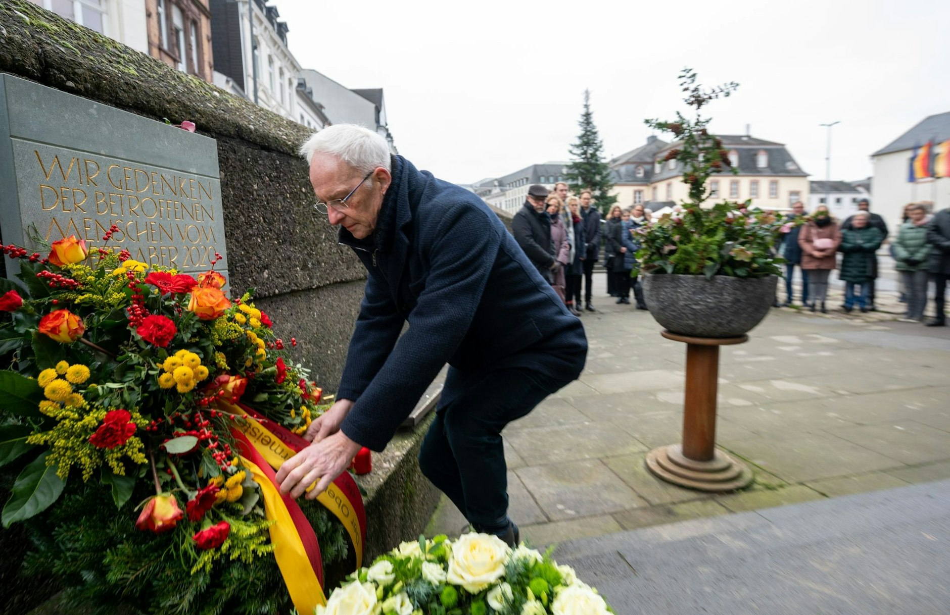 Triers Oberbürgermeister Wolfram Leibe  richtet die Schleife am Kranz, der für die Opfer einer Amokfahrt am 1. Dezember 2020 in Trier niedergelegt wurde. Ein Mann war mit seinem Geländewagen durch die Fußgängerzone gerast - fünf Menschen starben.  