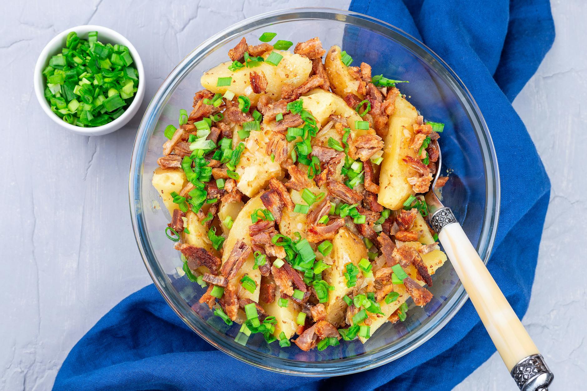 Das leckere Rezept für Kartoffelsalat setzt auf Bacon und angebratene Zwiebeln.