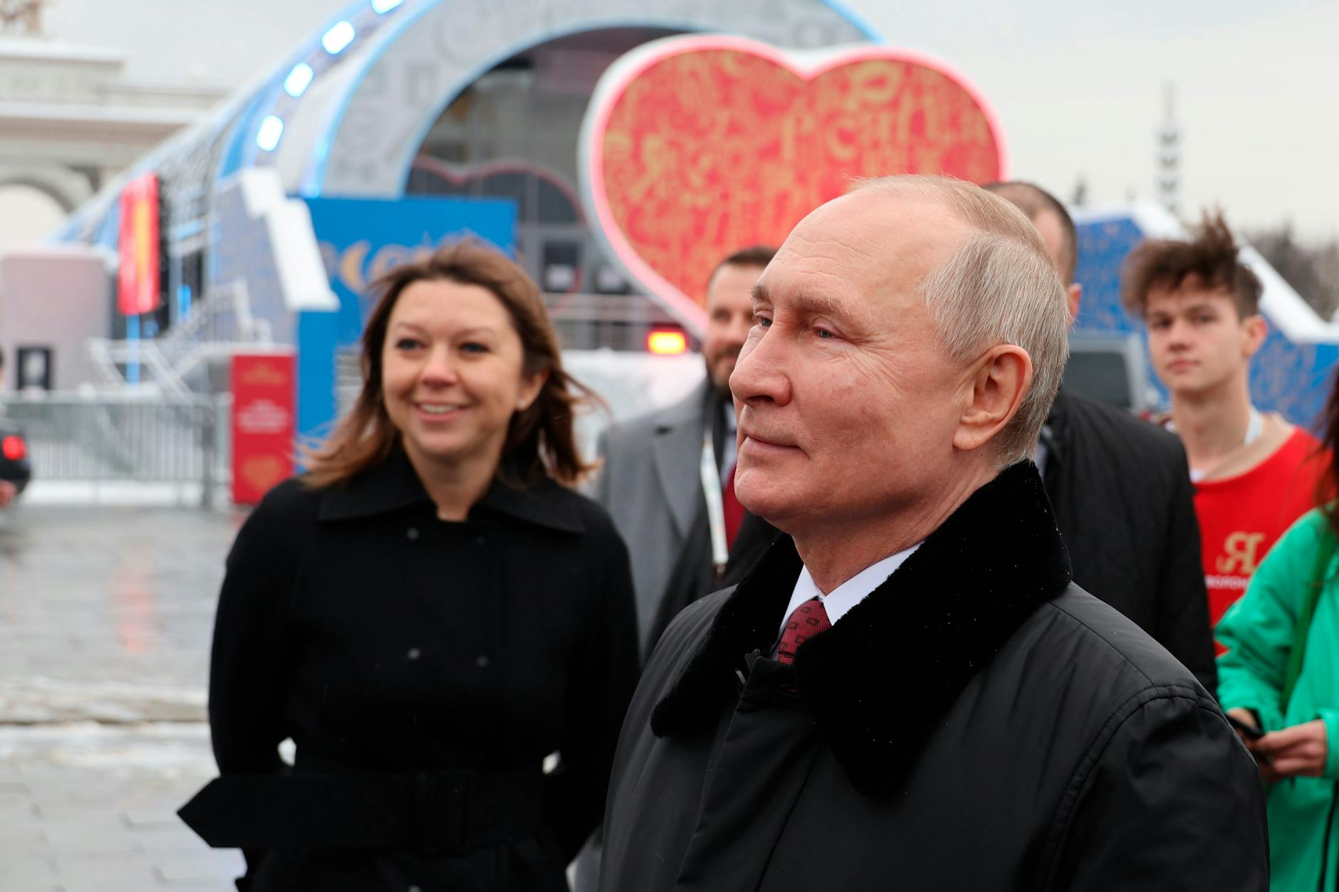 Wladimir Putin besucht eine Ausstellung über die Errungenschaften der Volkswirtschaft, Gäste stehen dicht neben ihm. 