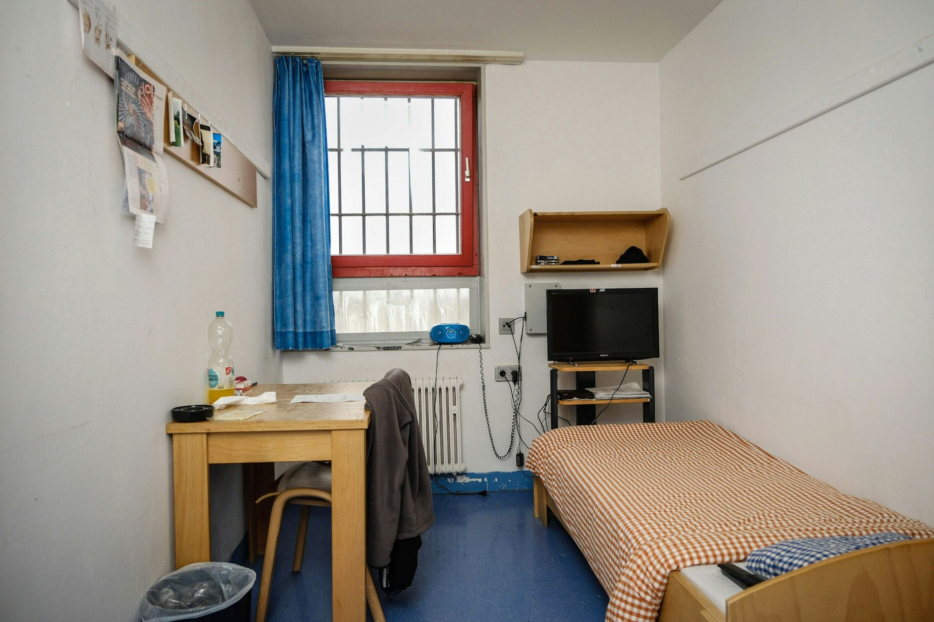 Eine Zelle in der JA Hameln, neun Quadratmeter groß. Ein Bett mit dünner Matratze, ein Schrank schmal wie ein Spind, Tisch, Stuhl, ein vergittertes Fenster, eine Toilette mit Tür.