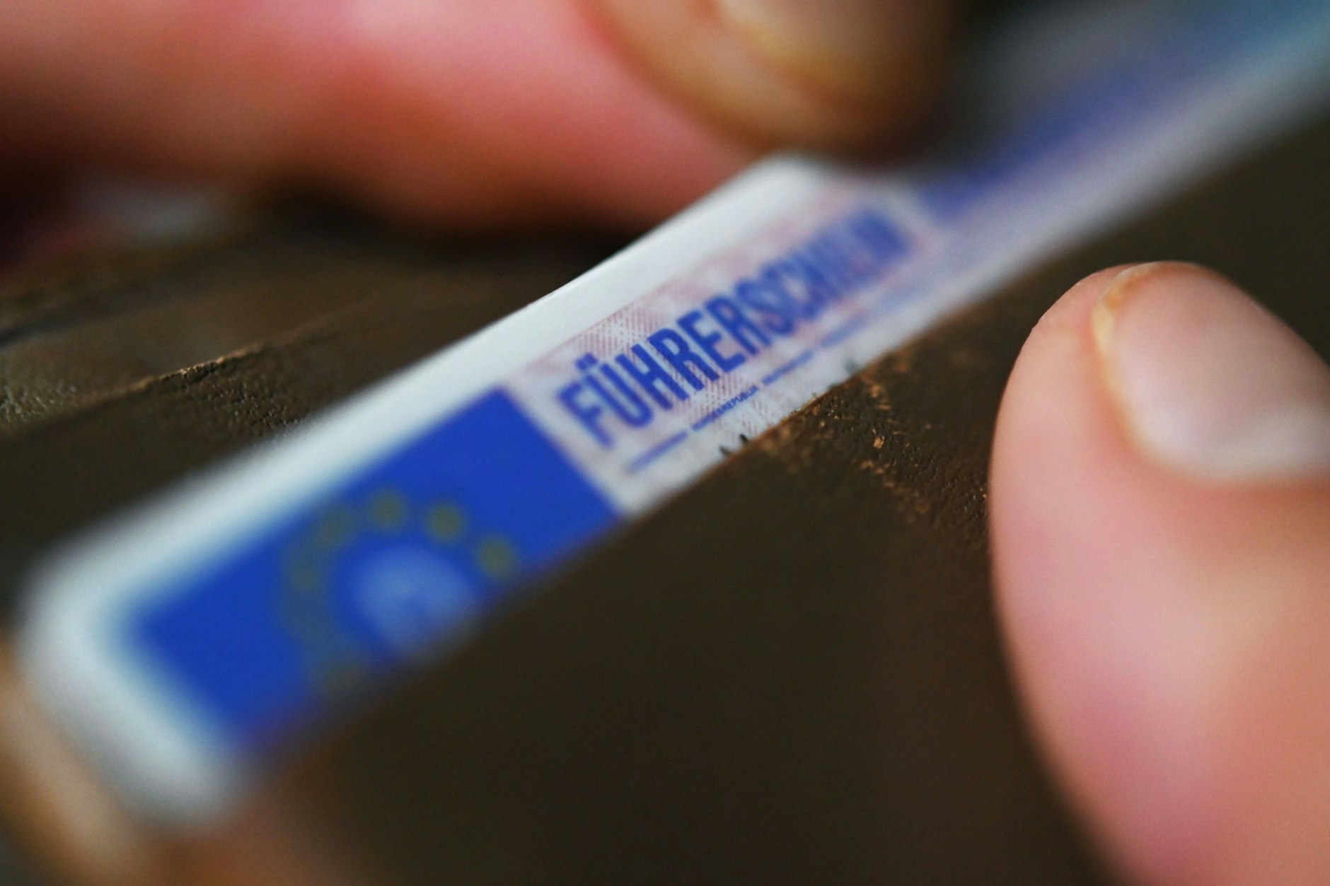 Eine Frau nimmt einen Führerschein aus ihrer Geldbörse.