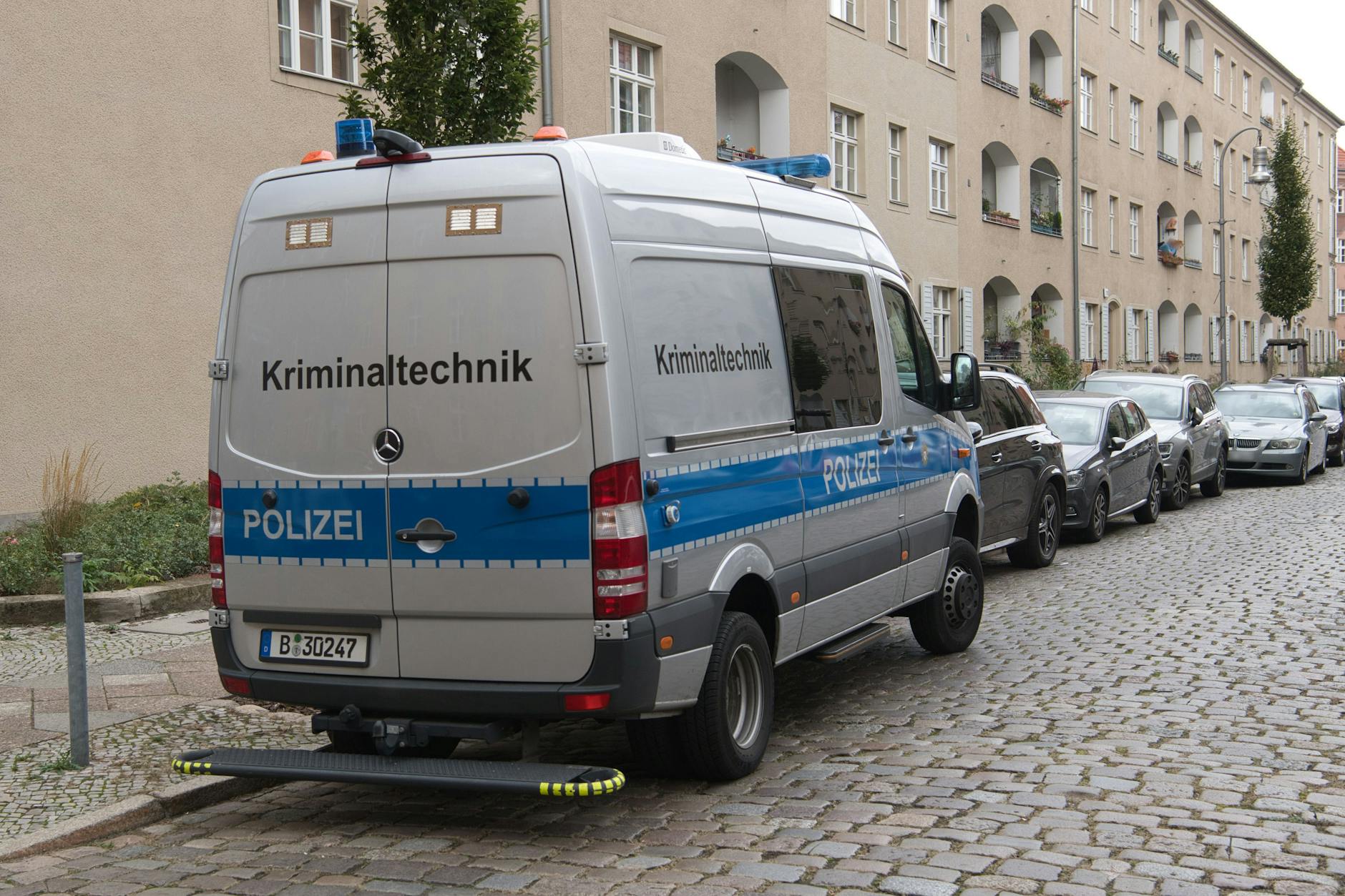 Berlin: Ein Einsatzfahrzeug der Kriminaltechnik der Polizei steht vor einer Häuserzeile (Symbolbild).