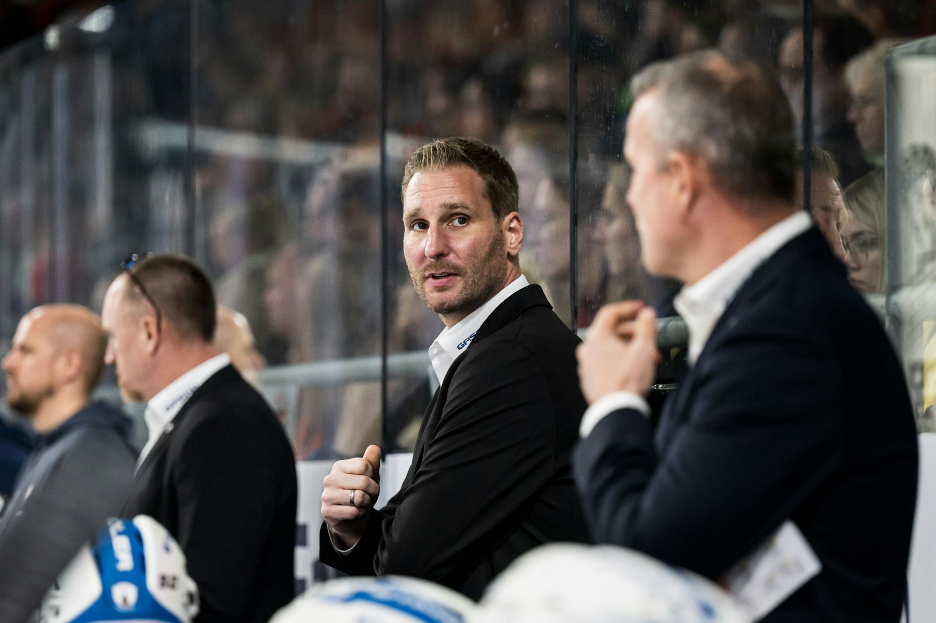 André Rankel (M.) achtet auf der Bank der Eisbären genau darauf, was Chefcoach Serge Aubin (r.) macht und sagt.&nbsp;