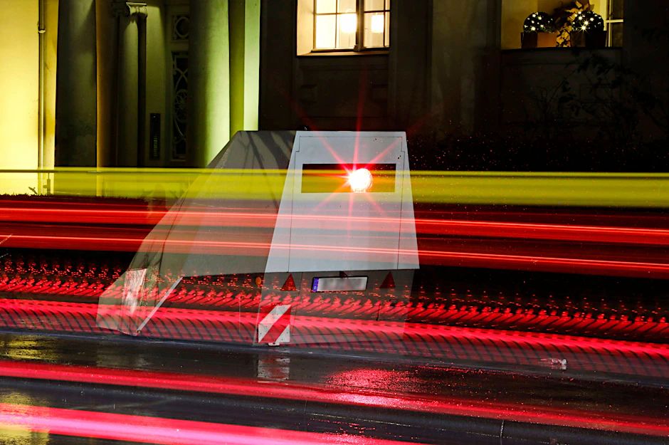 Eine Blitzsäule mit kombinierter Überwachung von Rotlicht und Geschwindigkeit steht an einer Ampelkreuzung in der Innenstadt.