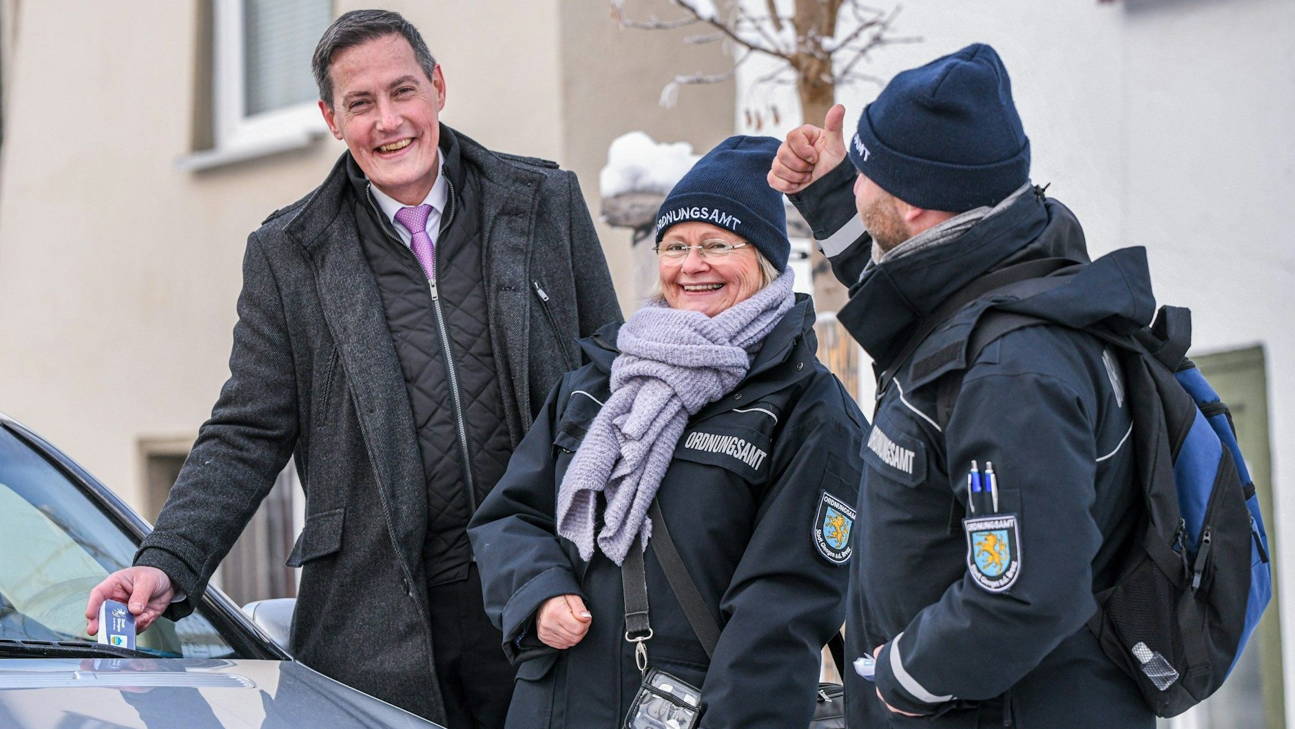 Oberbürgermeister Dieter Henle (l) steht mit zwei Mitarbeitern des Ordnungsamtes auf einem Parkplatz in Giengen an der Brenz. Hier werden Richtigparker belohnt.