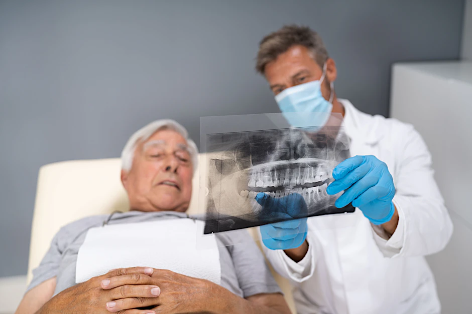 Ein Zahnarzt zeigt seinem Patienten ein Röntgenbild: Ist Zahnersatz fällig?