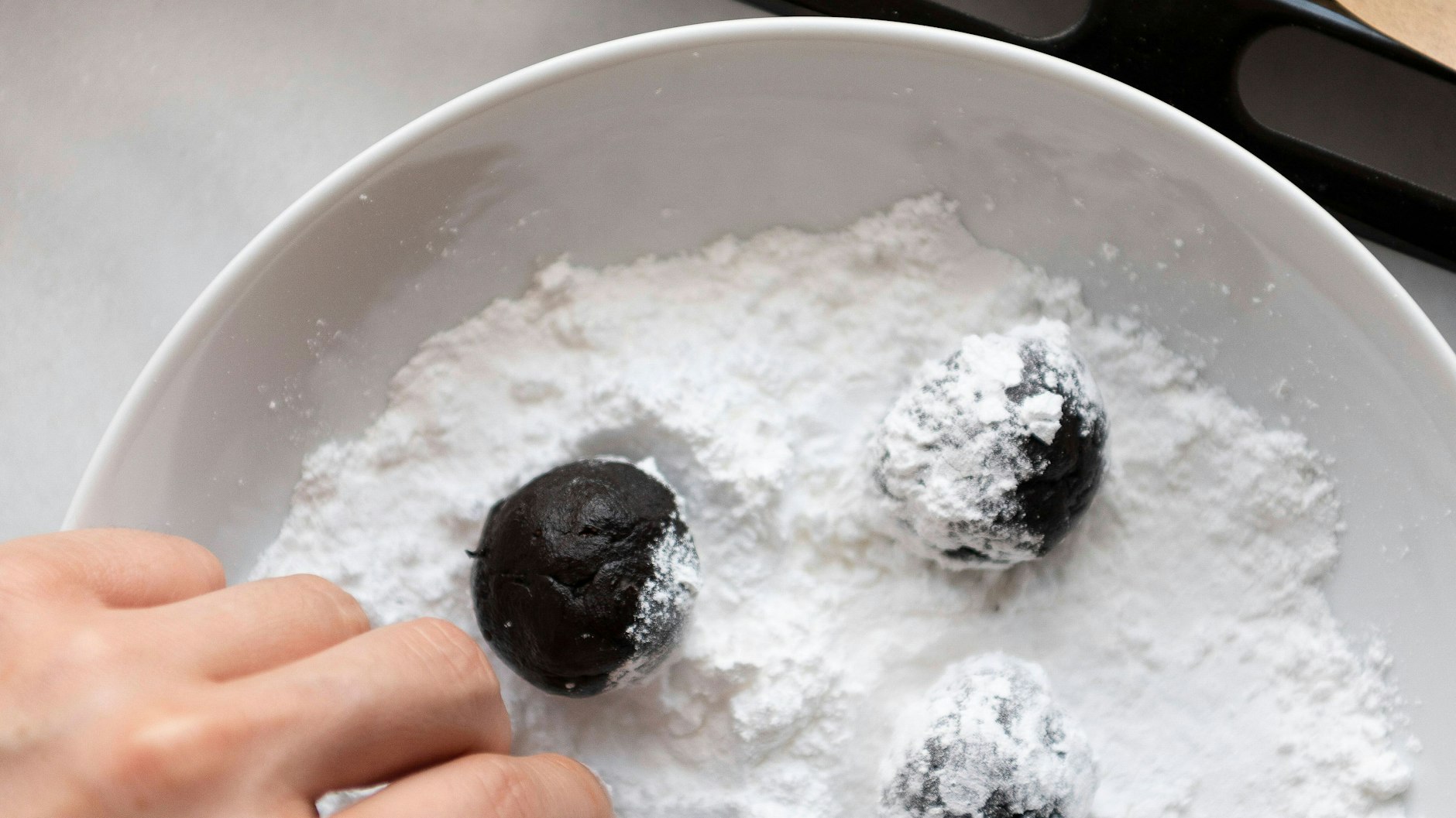 Laut Rezept werden die Crinkle Cookies vor dem Backen großzügig in Puderzucker gewälzt.