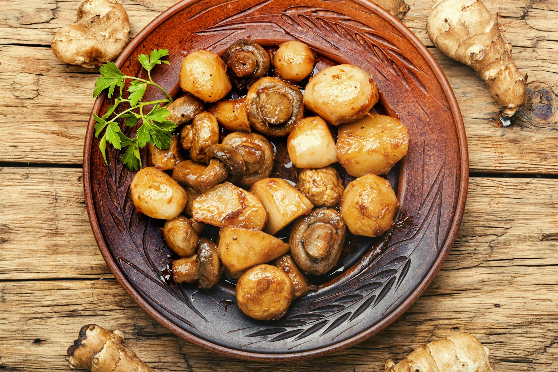 Dieses Rezept für Kartoffel-Pfanne mit Champignons ist einfach lecker - Parmesan verleiht dem Gemüse eine besonders würzige Note.