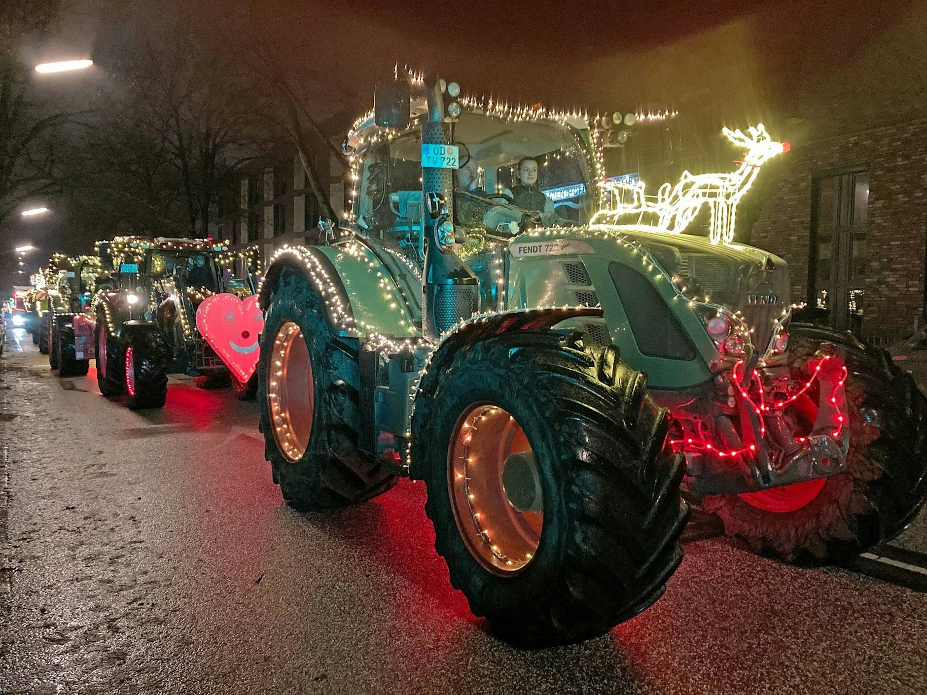 Weihnachtlich geschmückte Traktoren fahren in Hamburg eine Straße entlang. Sie sind auf dem Weg zum Universitätsklinikum Eppendorf, um dort Spenden abzugeben.  