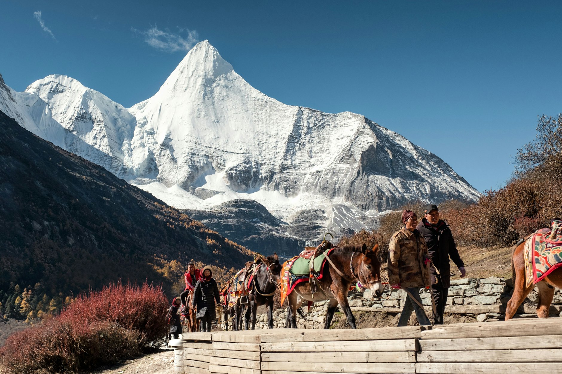 Touristenführer führen Besucher auf Pferden durch den Yading-Nationalpark