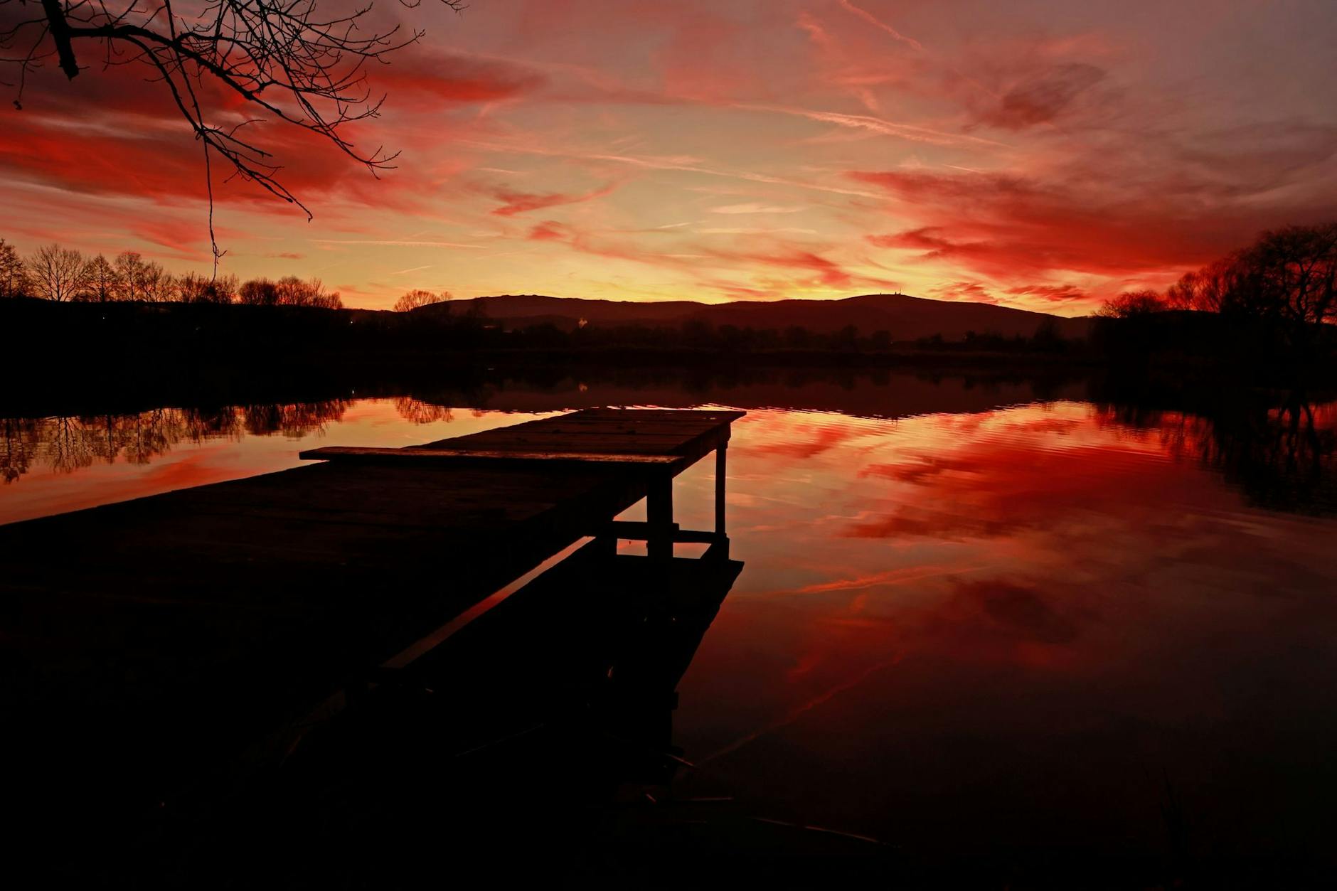 Der Tag geht zu Ende: Das Licht der untergehenden Sonne spiegelt sich in einem Teich bei Wernigerode. Die bunte Färbung des Himmels deutet auf eine Wetteränderung hin.