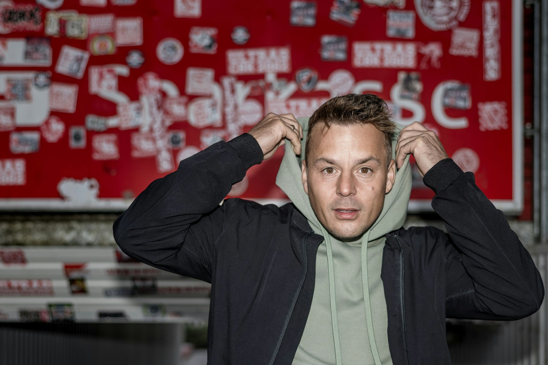 Der Sänger Alexander Knappe steht im Stadion der Freundschaft in einem Fanblock. 